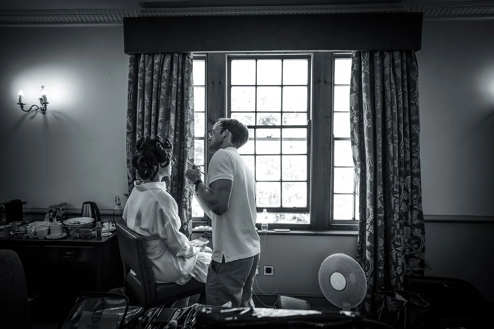 Black and white - bride at window during bridal prep, Nunsmere Hall hotel