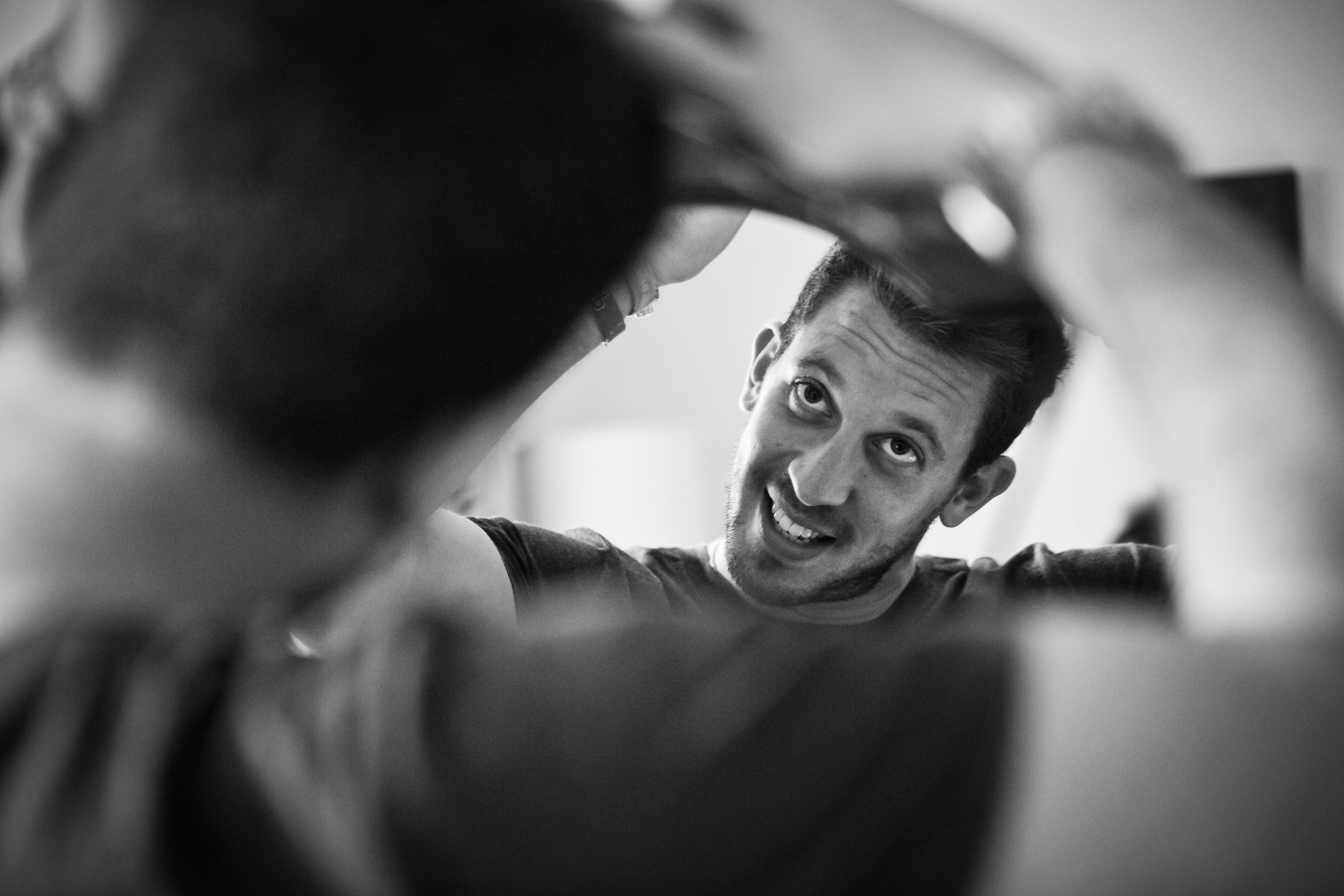 groom does his hair in mirror during prep at last drop wedding venue