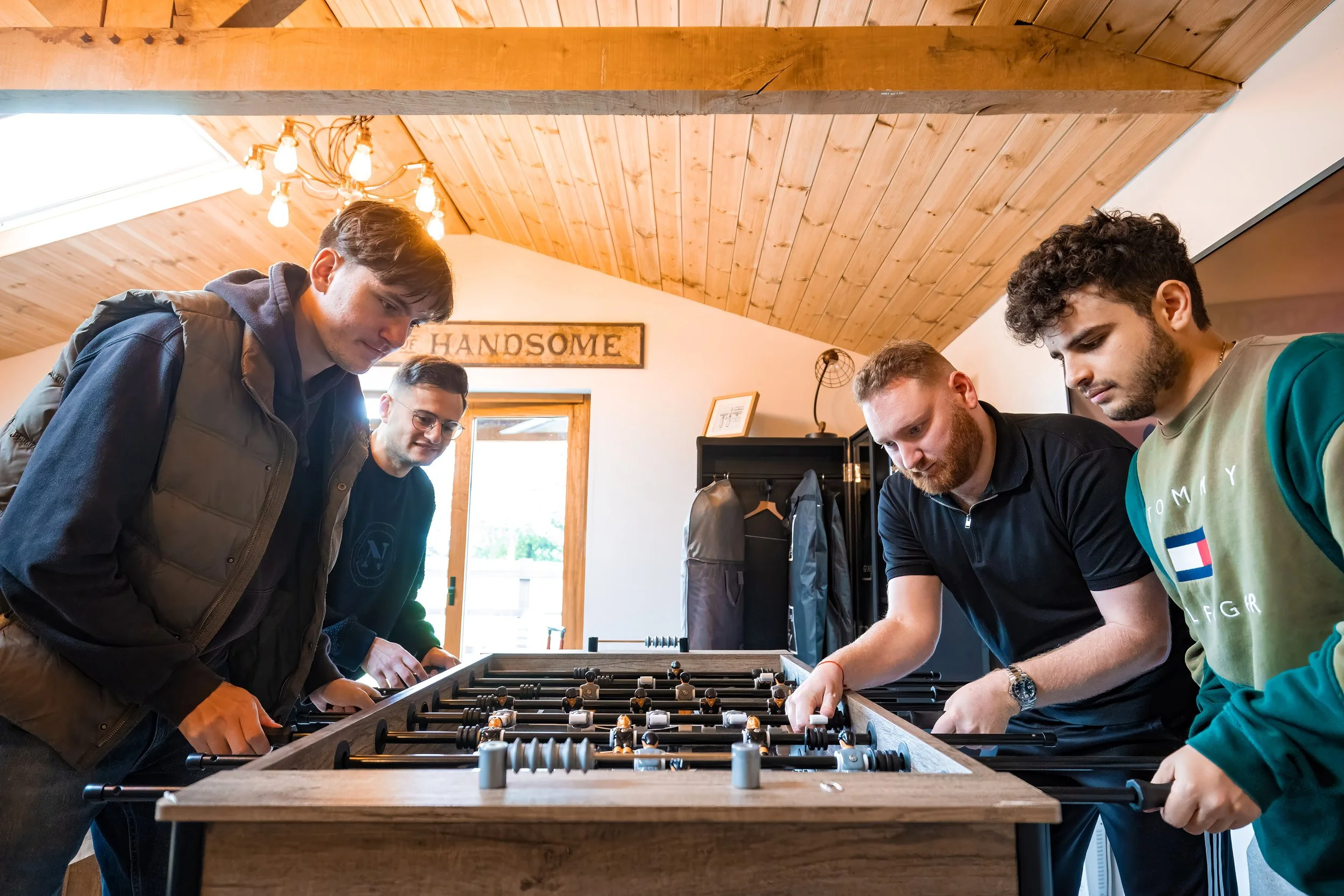 Merrydale Manor wedding groomsmen playing foosball in games room – wedding photography Cheshire