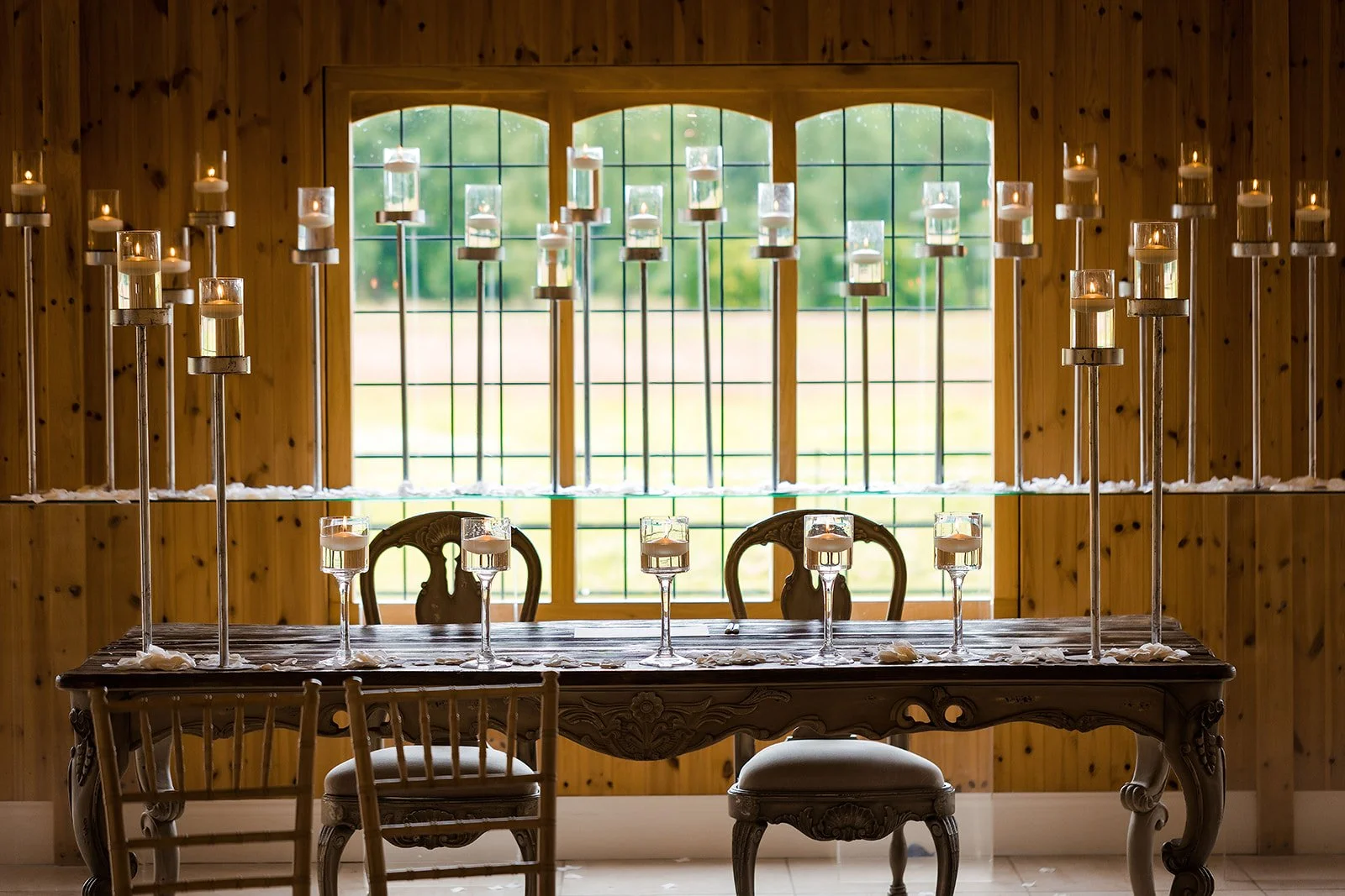 Merrydale Manor wedding table candles and flower petals by window – Manchester wedding photographer