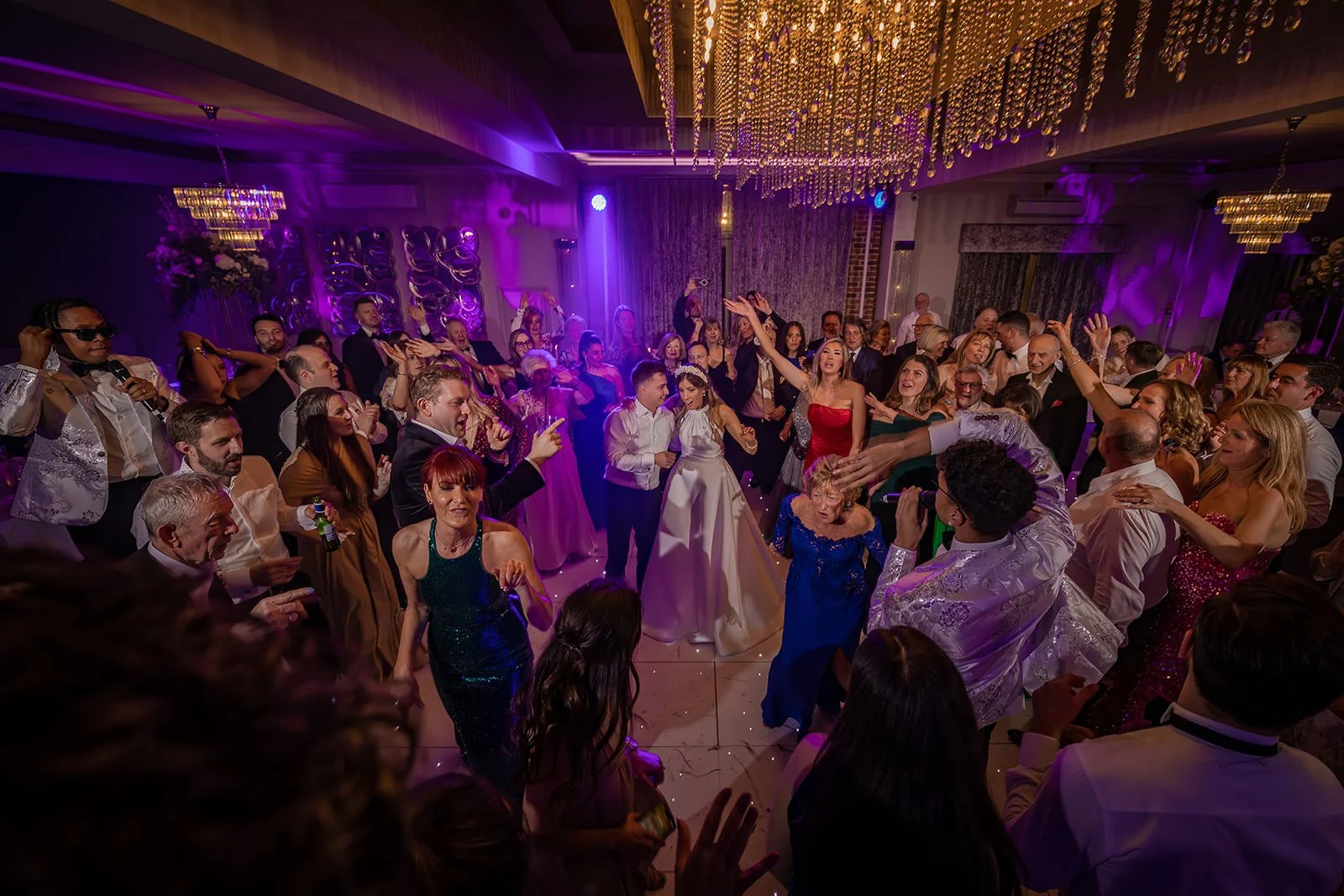Merrydale Manor wedding reception guests dancing under chandelier – fine art wedding photographer North West