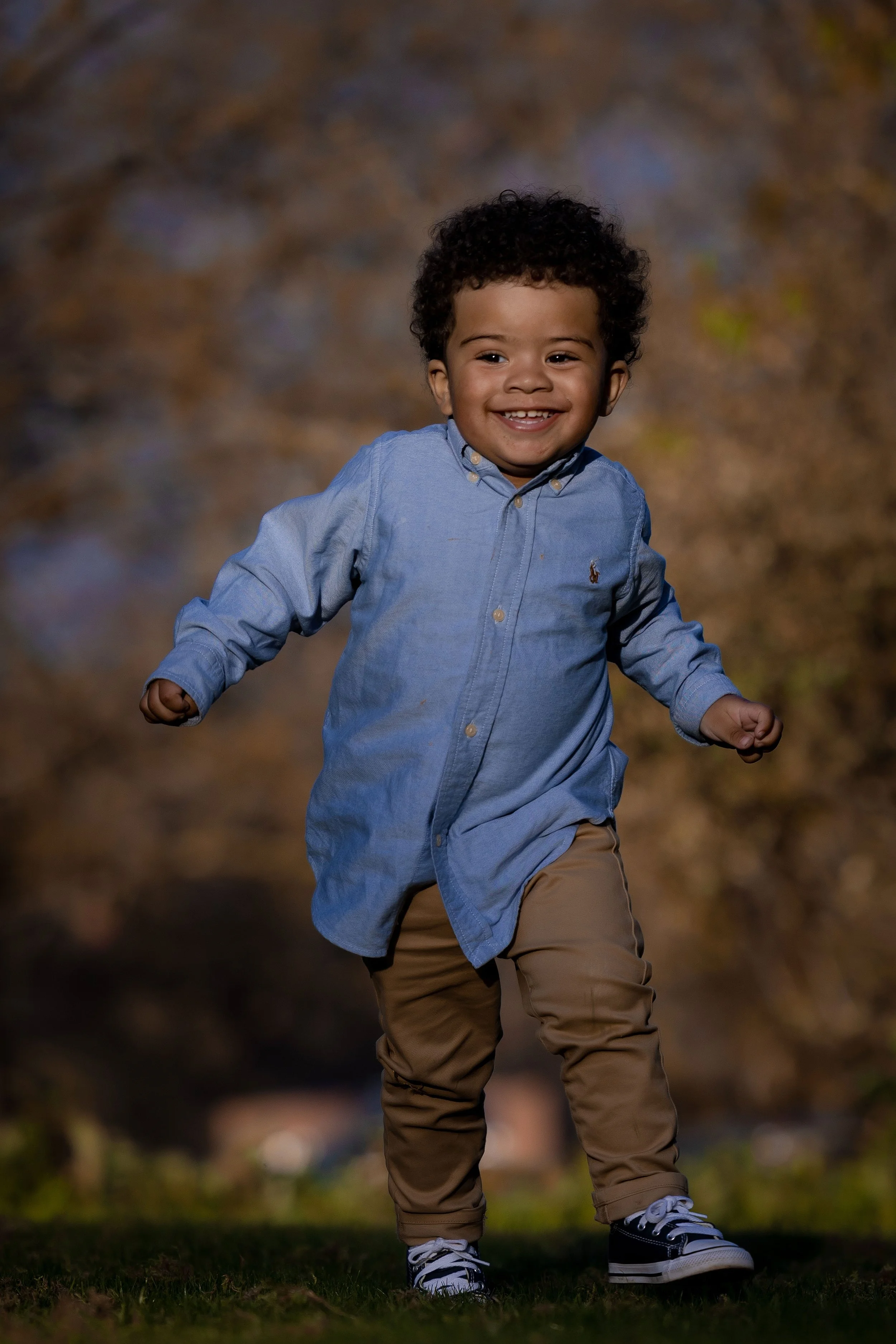smiling running boy portrait with natural light in garden