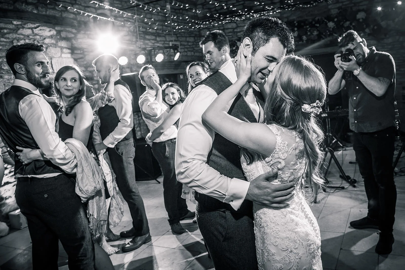 Bride and groom share a kiss on dance floor of evening wedding party