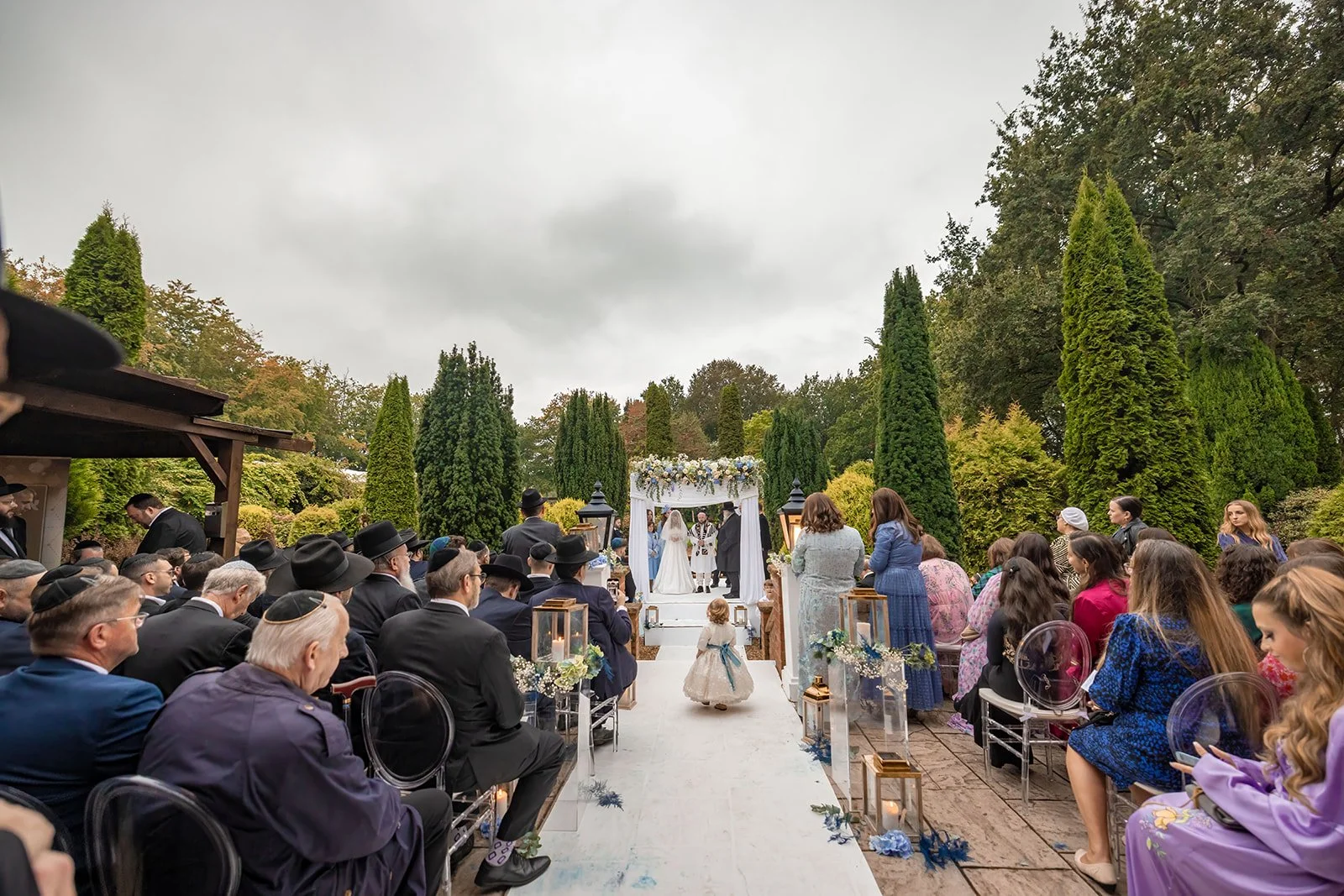 Wide shot of bride walking down the aisle, outdoor ceremony at Nunsmere Hall Italian gardens