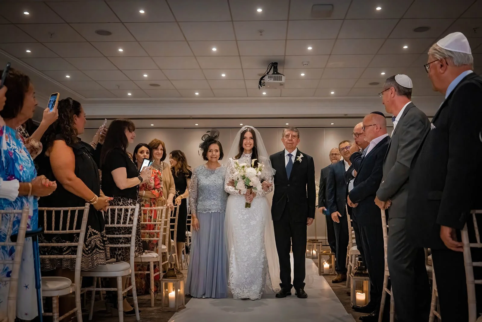bride and parents walk down aisle at start of indoor wedding ceremony at worsley marriott hotel
