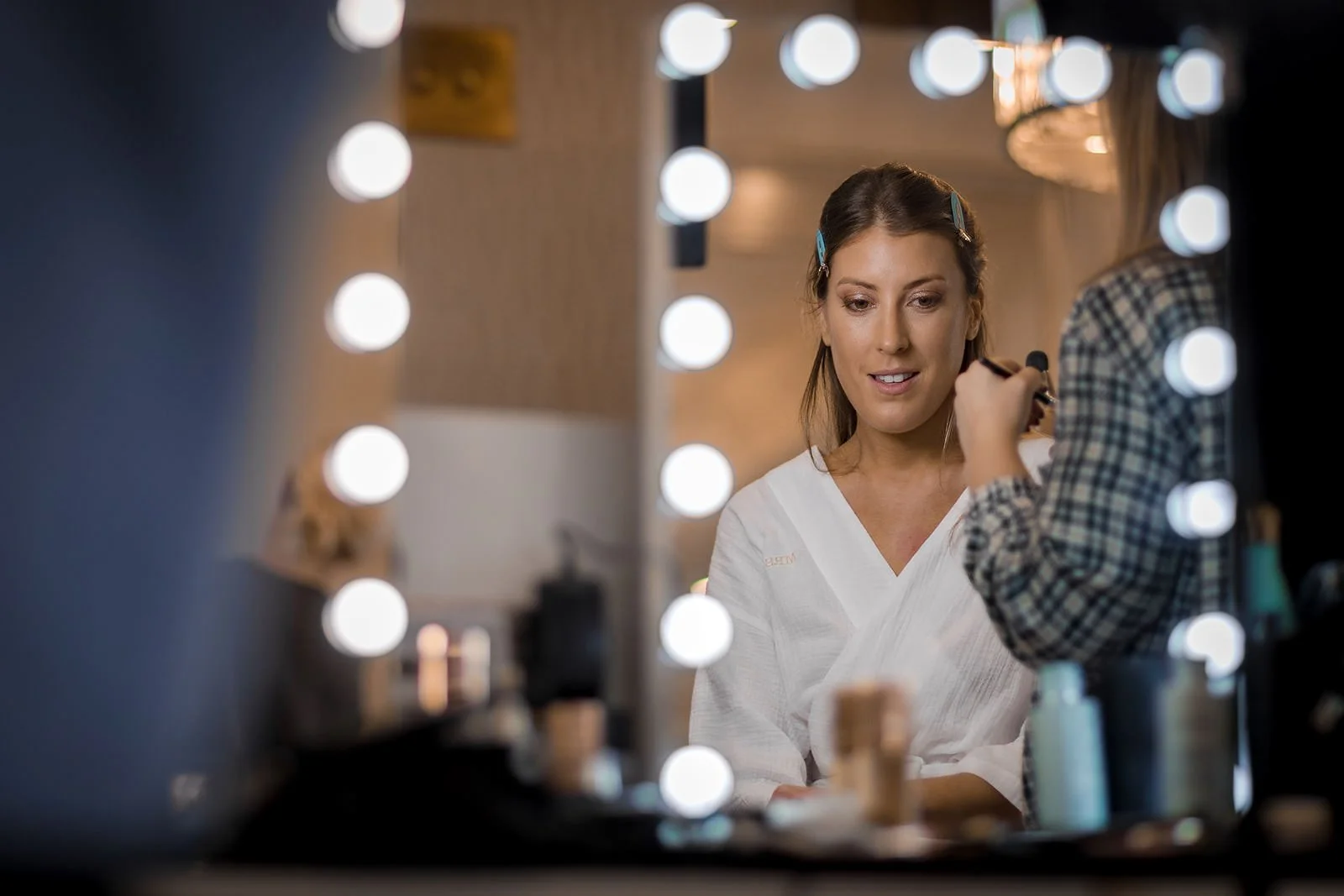 bride in mirror having make up done during bridal prep at Merrydale Manor in Cheshire