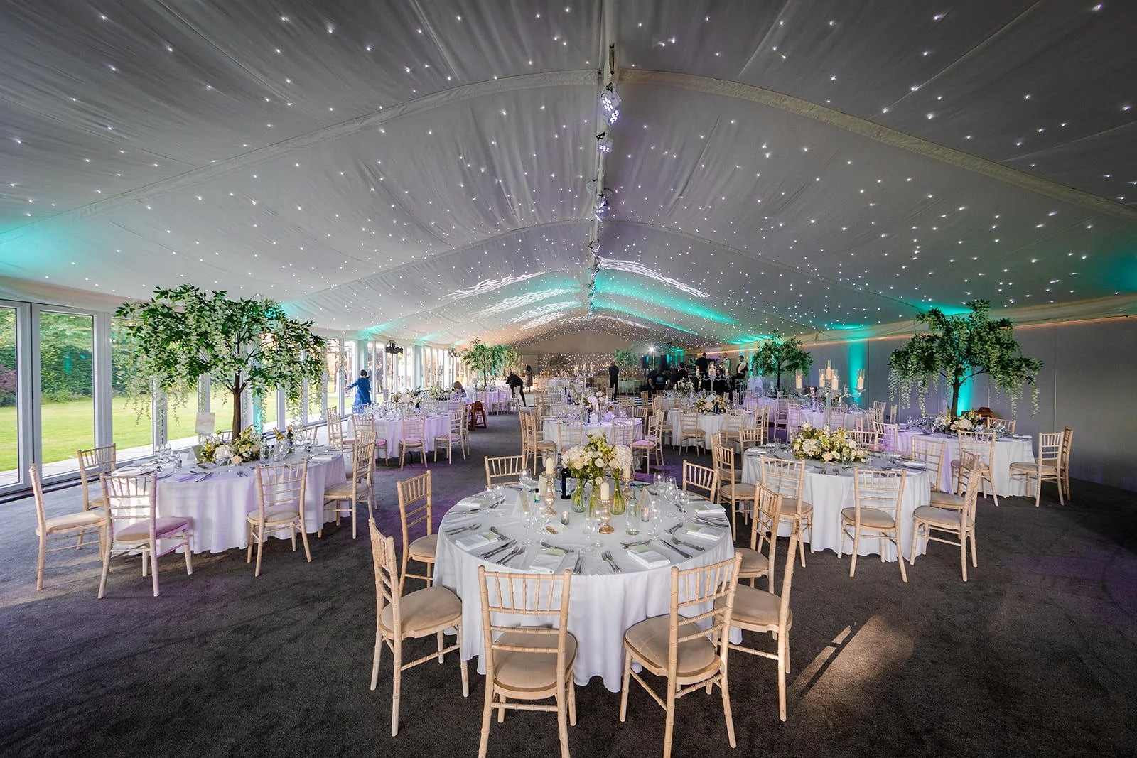 nunsmere hall wedding marquee reception set up with tables, chairs, star lighting and decor