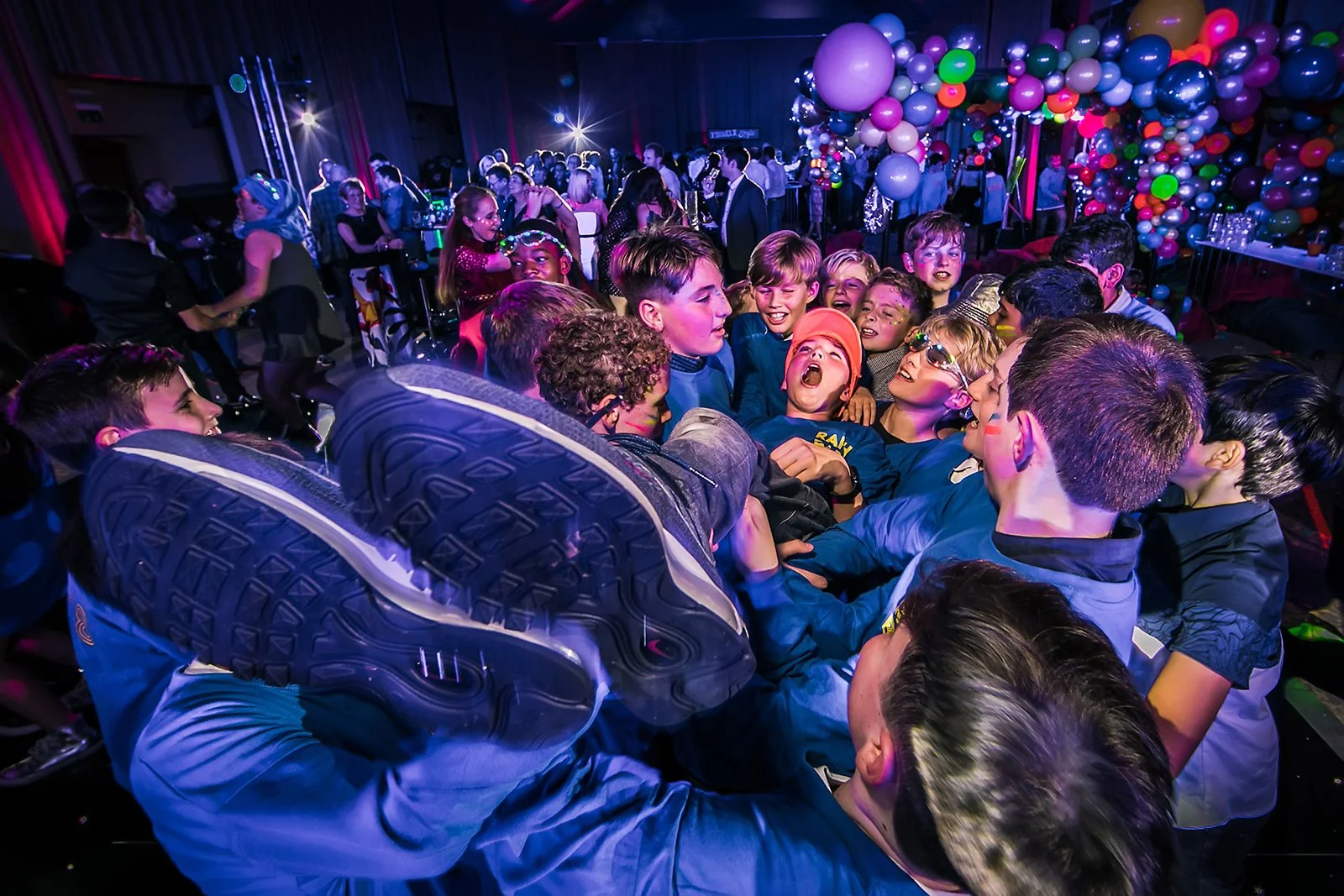barmitzvah boy lifted off his feet by friends on the dance floor during his celebrations