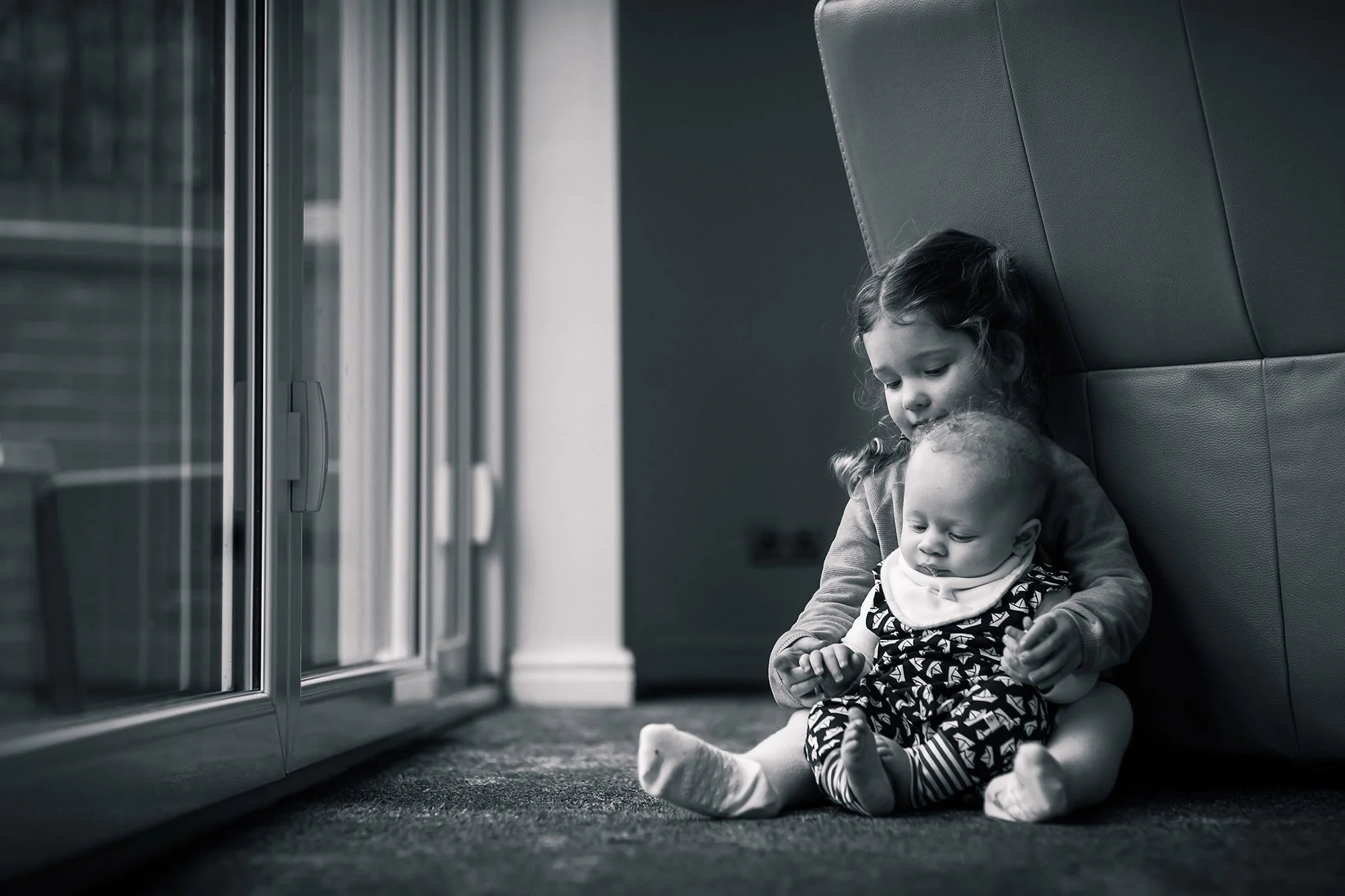 black and white natural light portrait of cousins playing