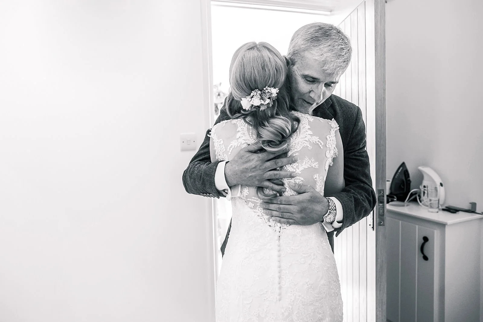 Emotional moment as father hugs bride on wedding day during prep