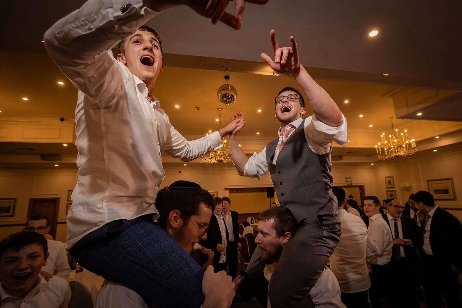groom on shoulders during wedding party reception at last drop village in bolton
