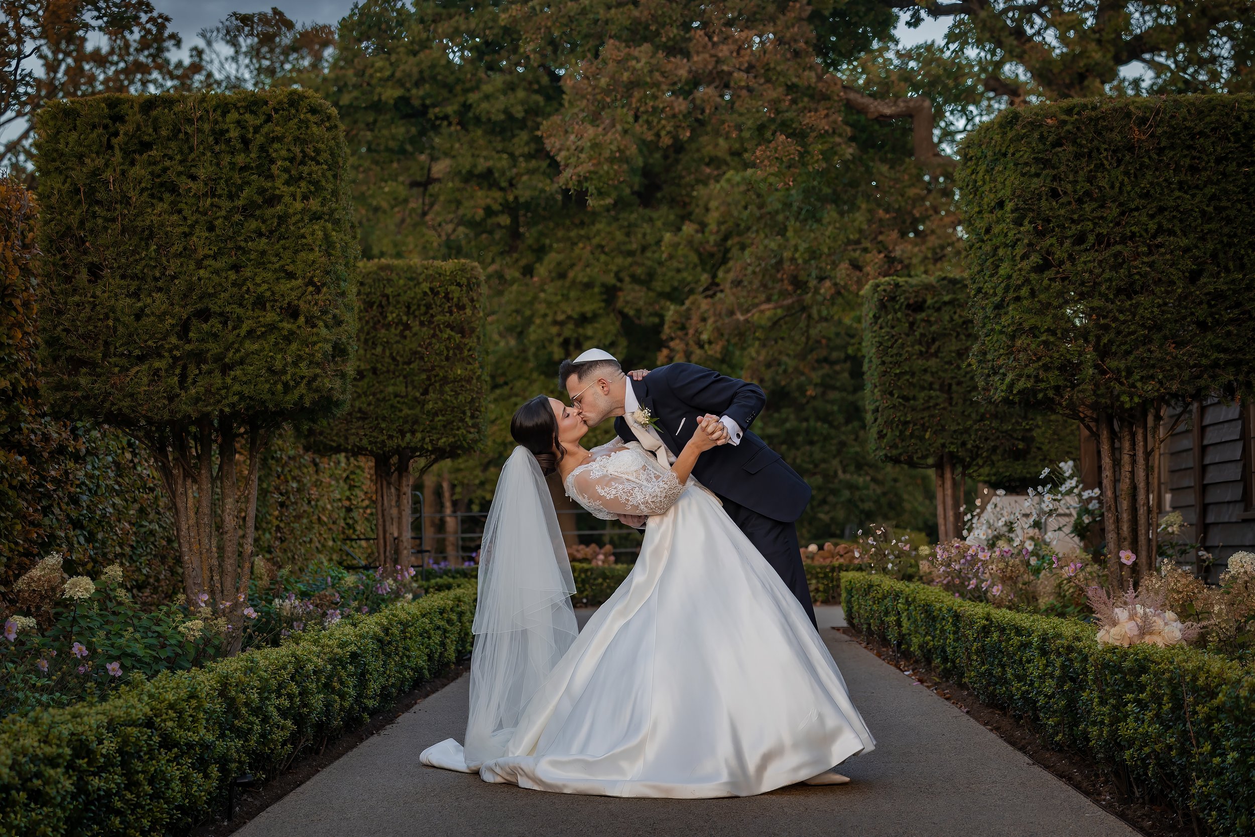 Merrydale Manor wedding couple first kiss in formal garden – fine art wedding photographer North West