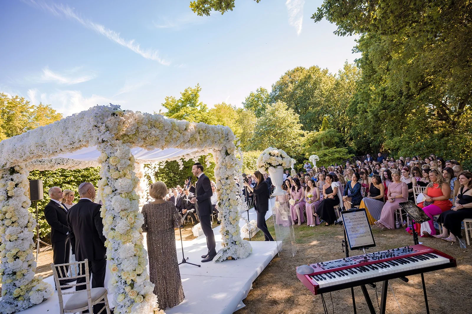 wide angle bride and groom exchange vows during outdoor wedding ceremony at nunsmere hall in cheshire