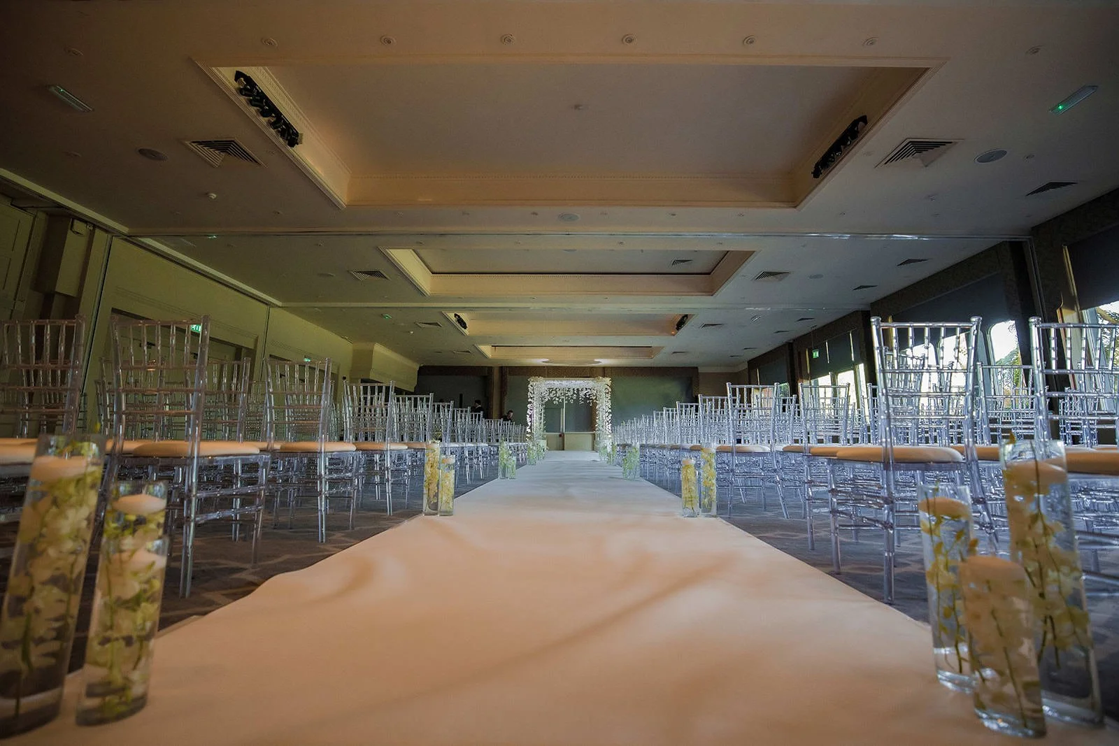 Clean ceremony room setup with white aisle and ghost chairs, Fairmont Cheshire The Mere

