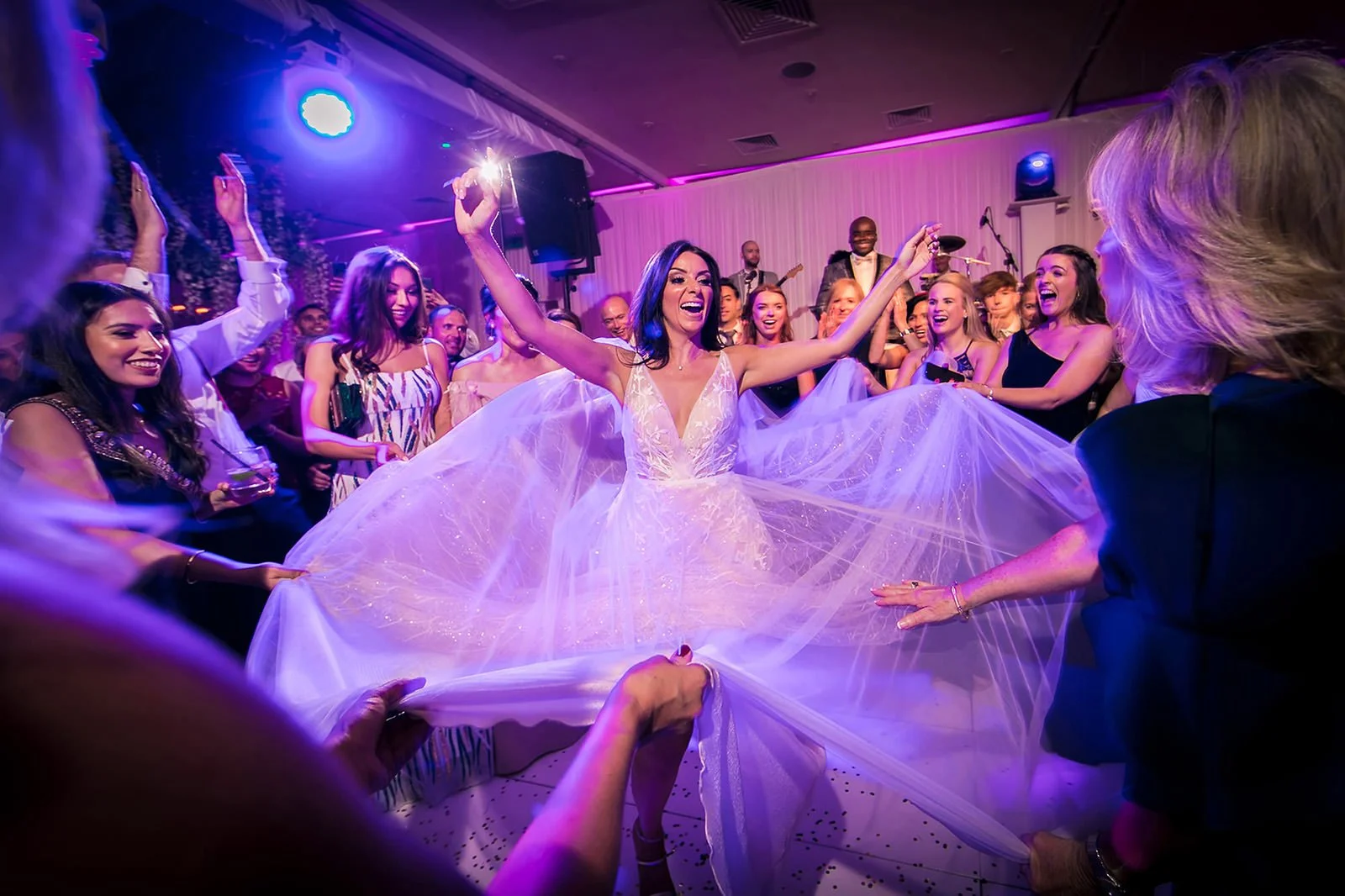 Bride has wedding dress fanned out by friends on dance floor at Mere Golf Club