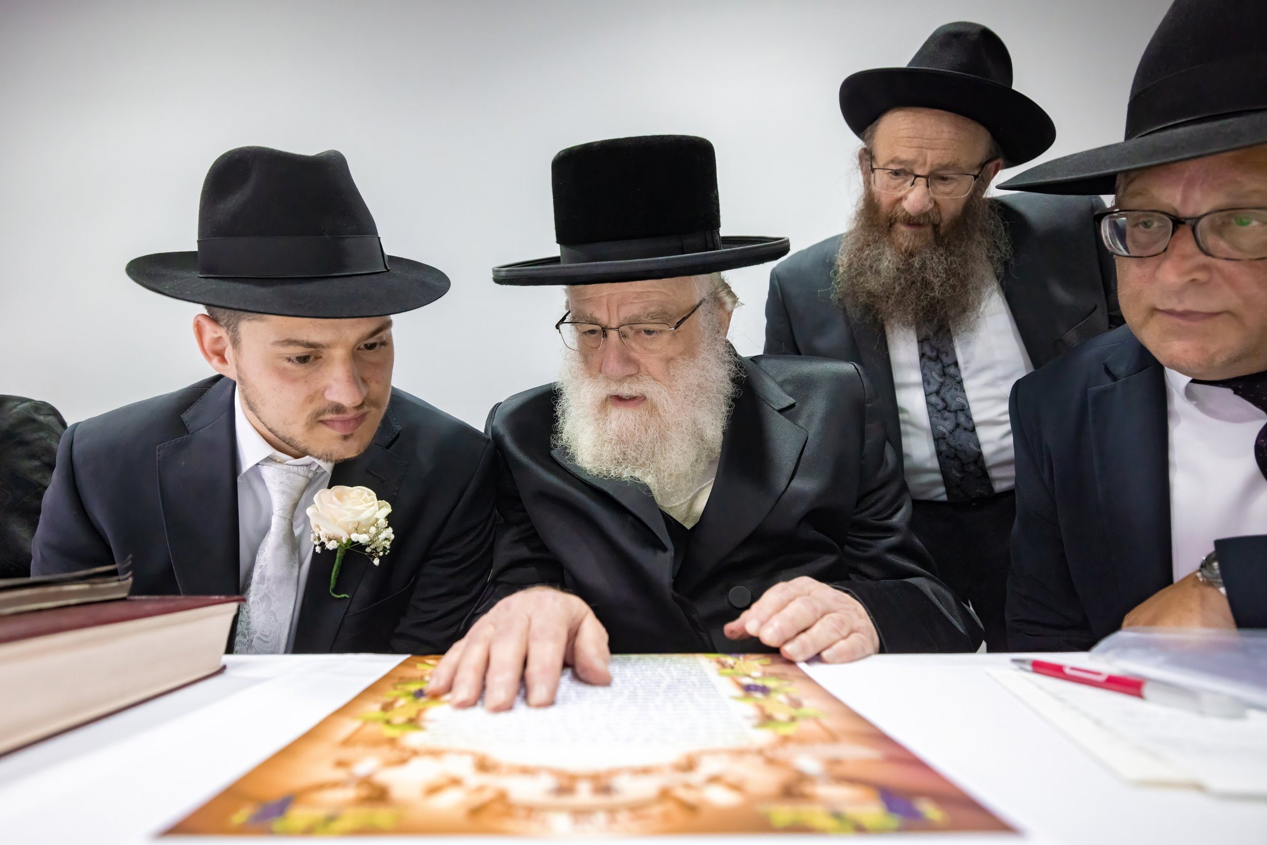 chosson groom looks at ketubah during tish at charedi jewish wedding
