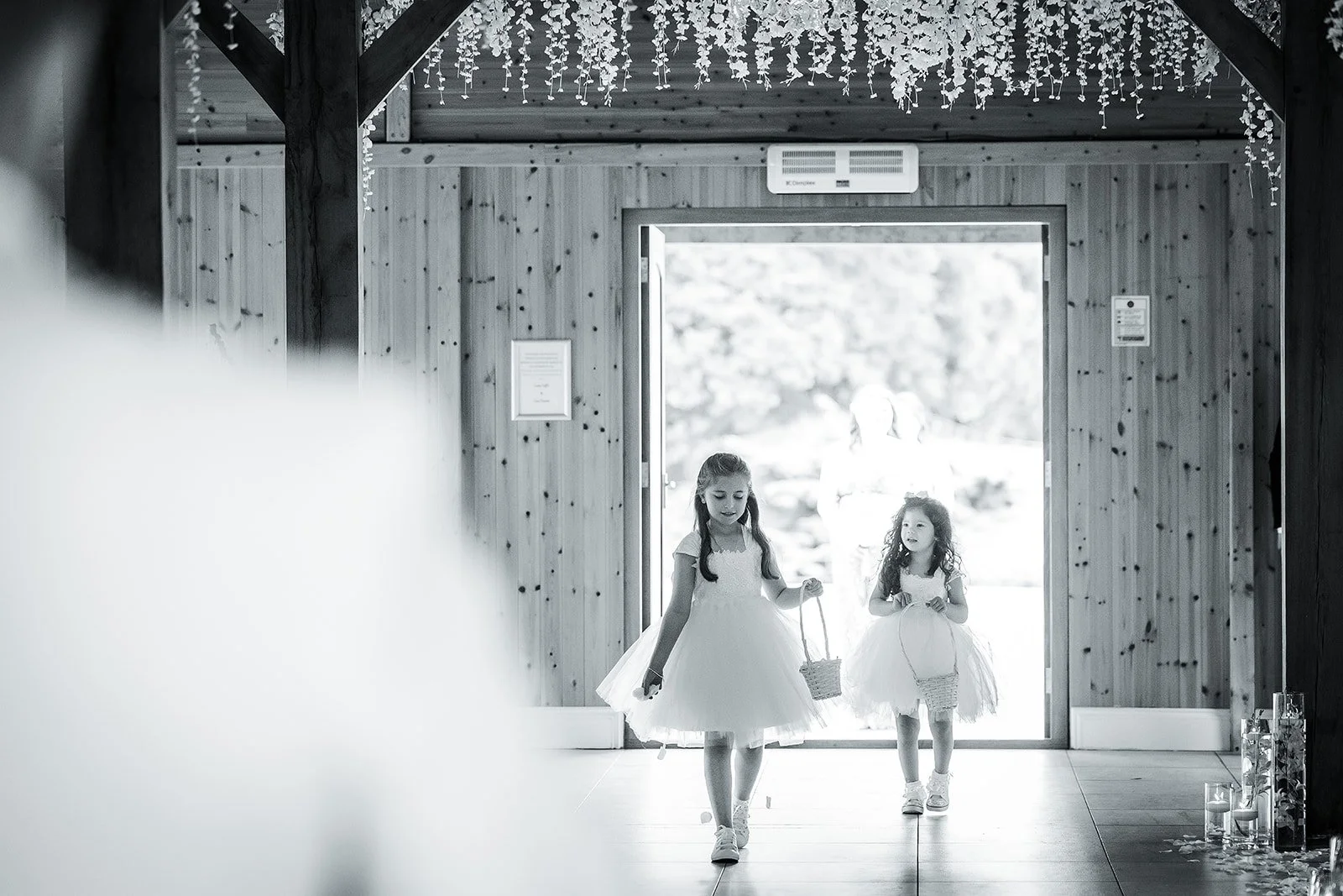 Merrydale Manor wedding flower girls with baskets through doorway – fine art wedding photographer North West