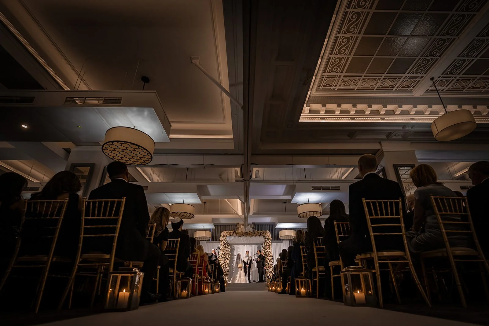 wide angle of bride and groom exchange vows during wedding ceremony in ballroom at kimpton clocktower manchester