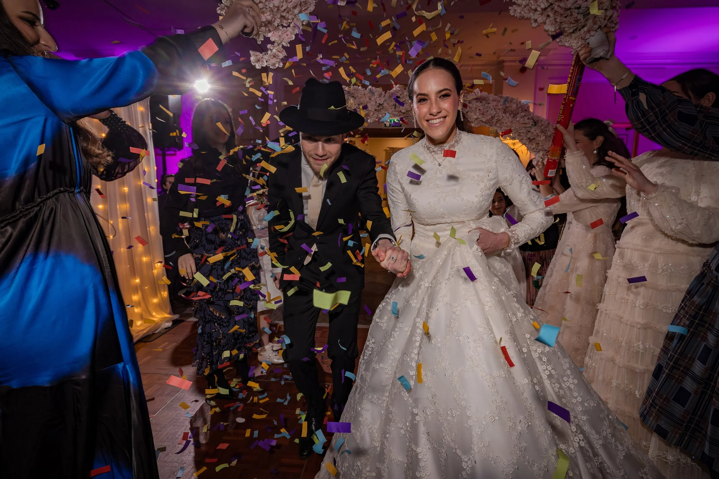 chosson groom and kallah bride make entrance onto dancefloor with confetti at charedi jewish wedding