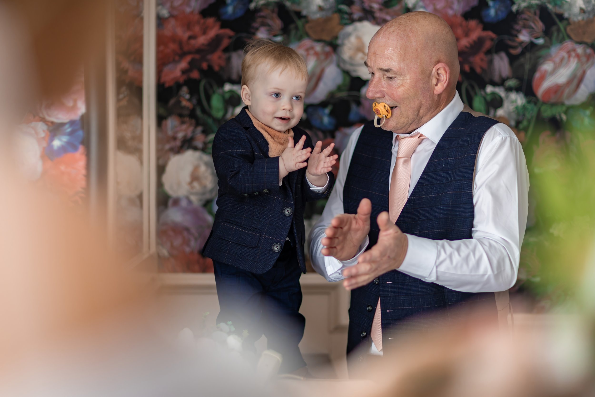 Page boy and grandfather playing during wedding prep