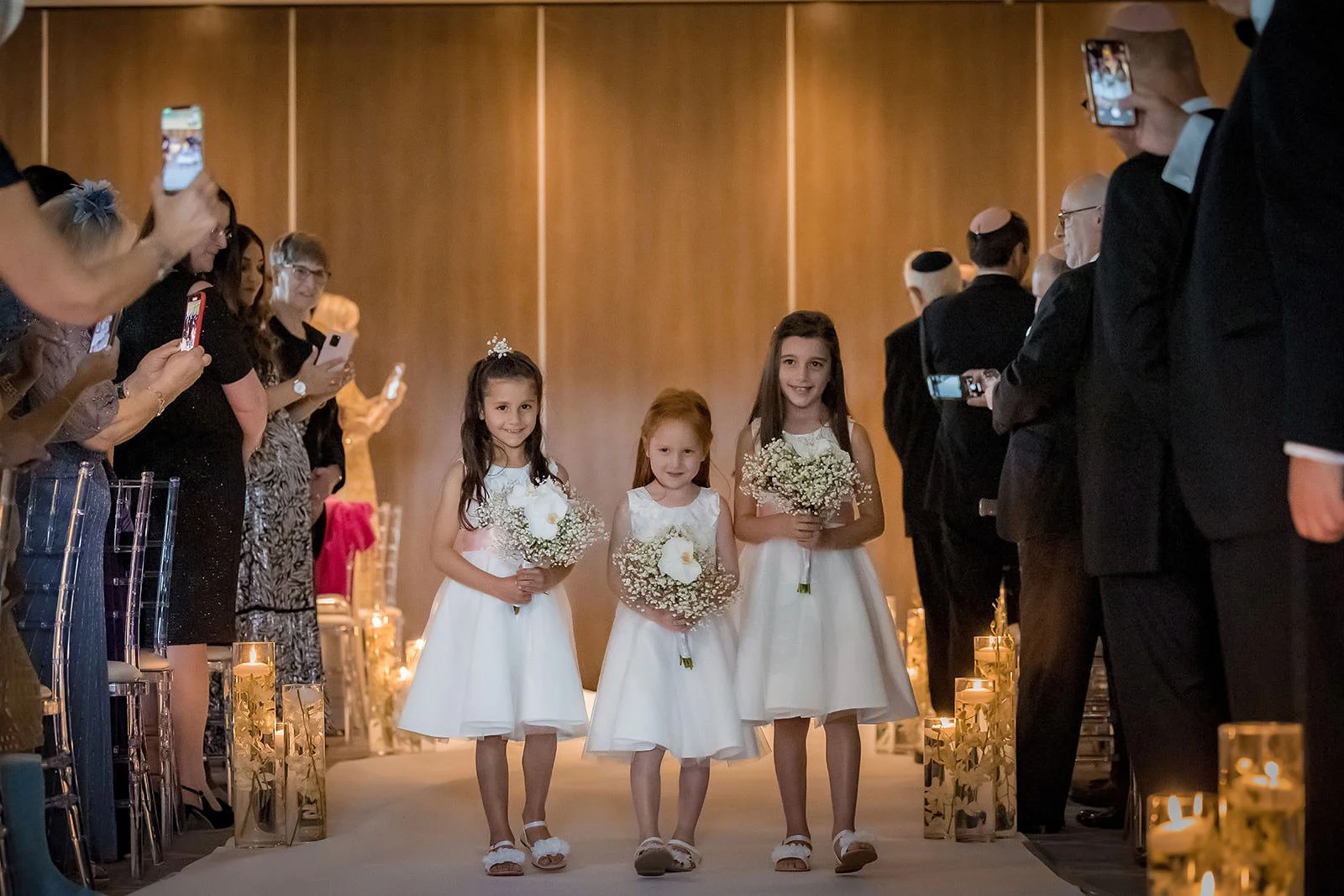 bridesmaids walk down aisle during wedding ceremony at mere golf resort in cheshire