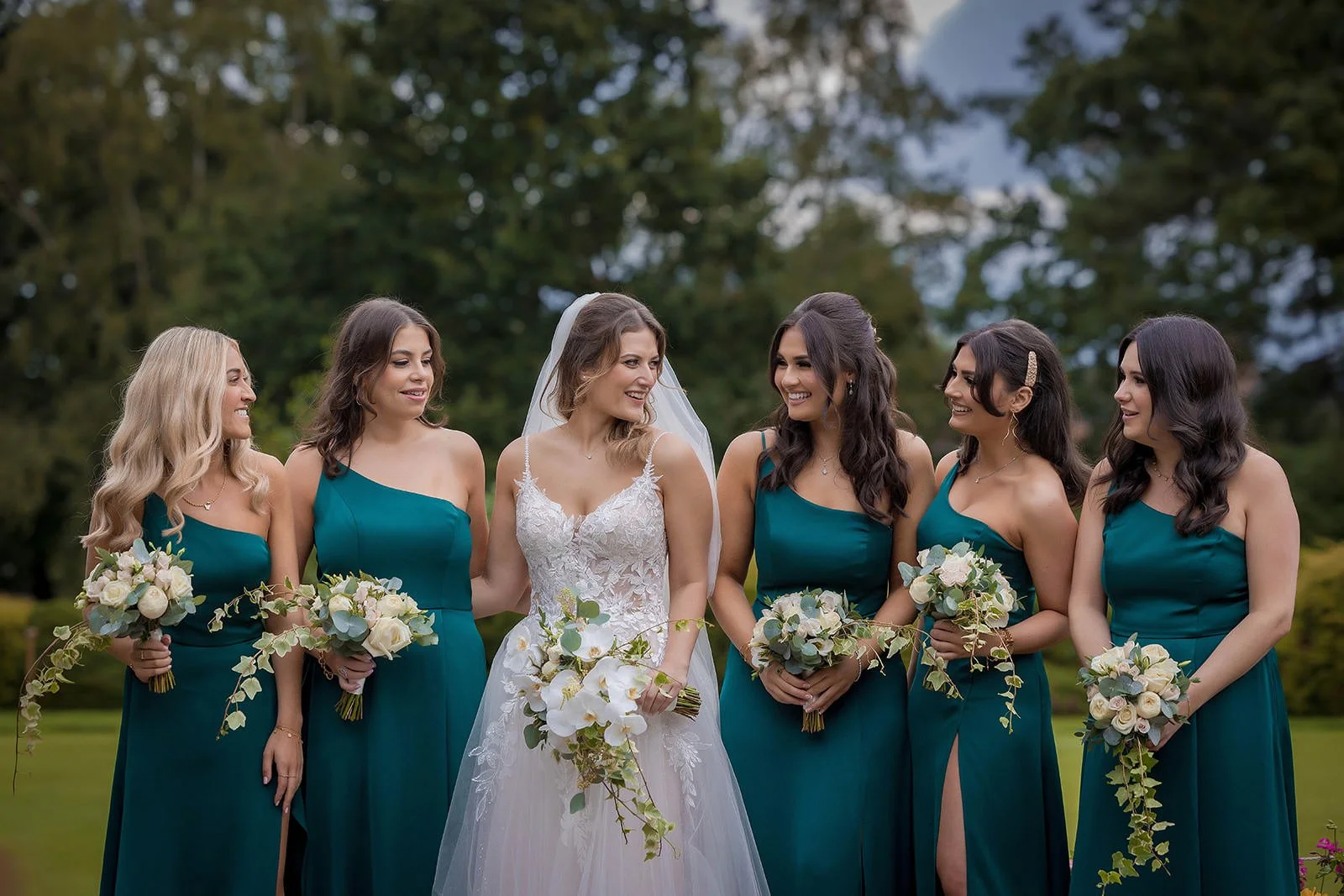 Bridesmaids in teal dresses with white bouquets, Fairmont Cheshire - The Mere
