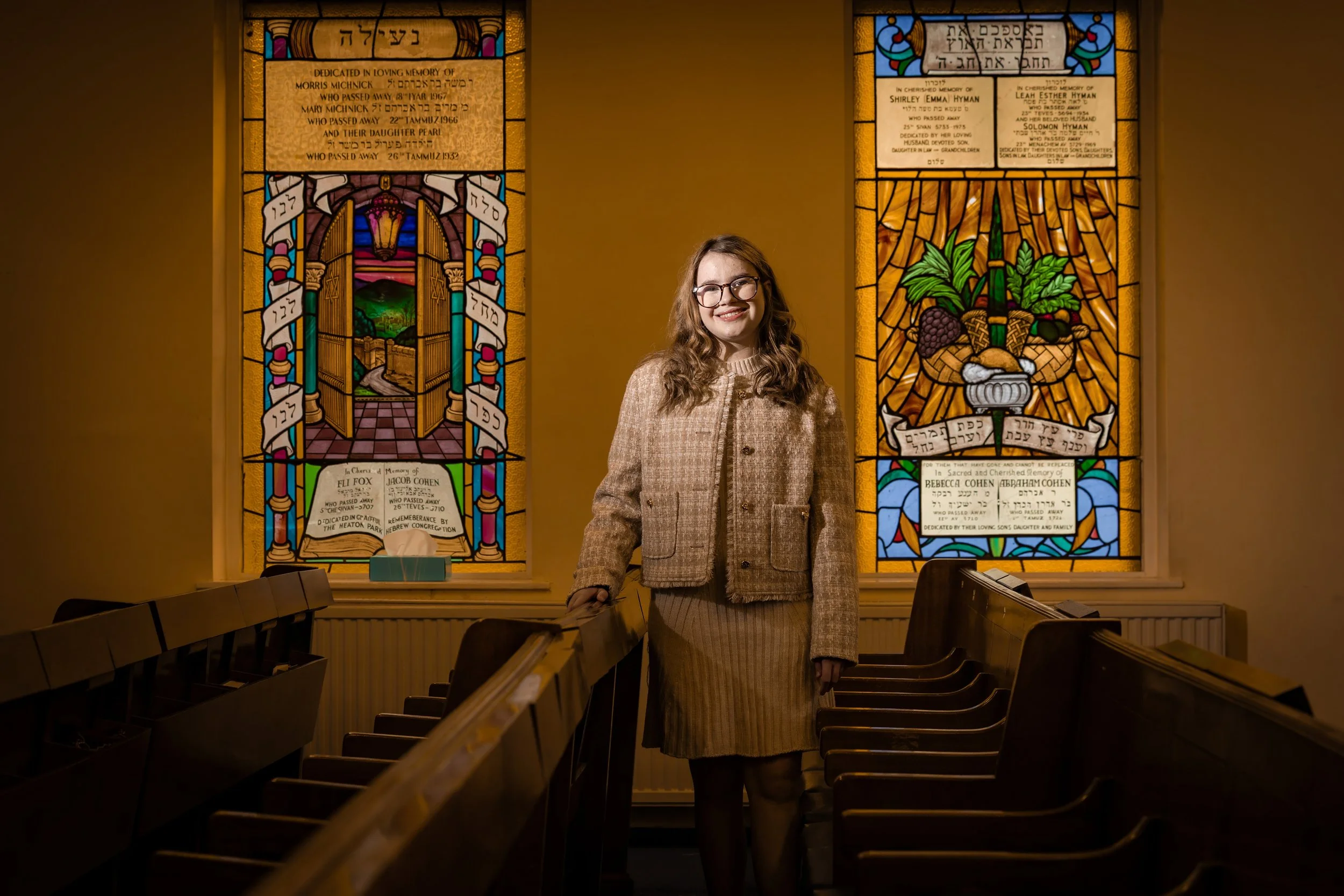 batmitzvah girl portrait in synagogue with stained glass windows