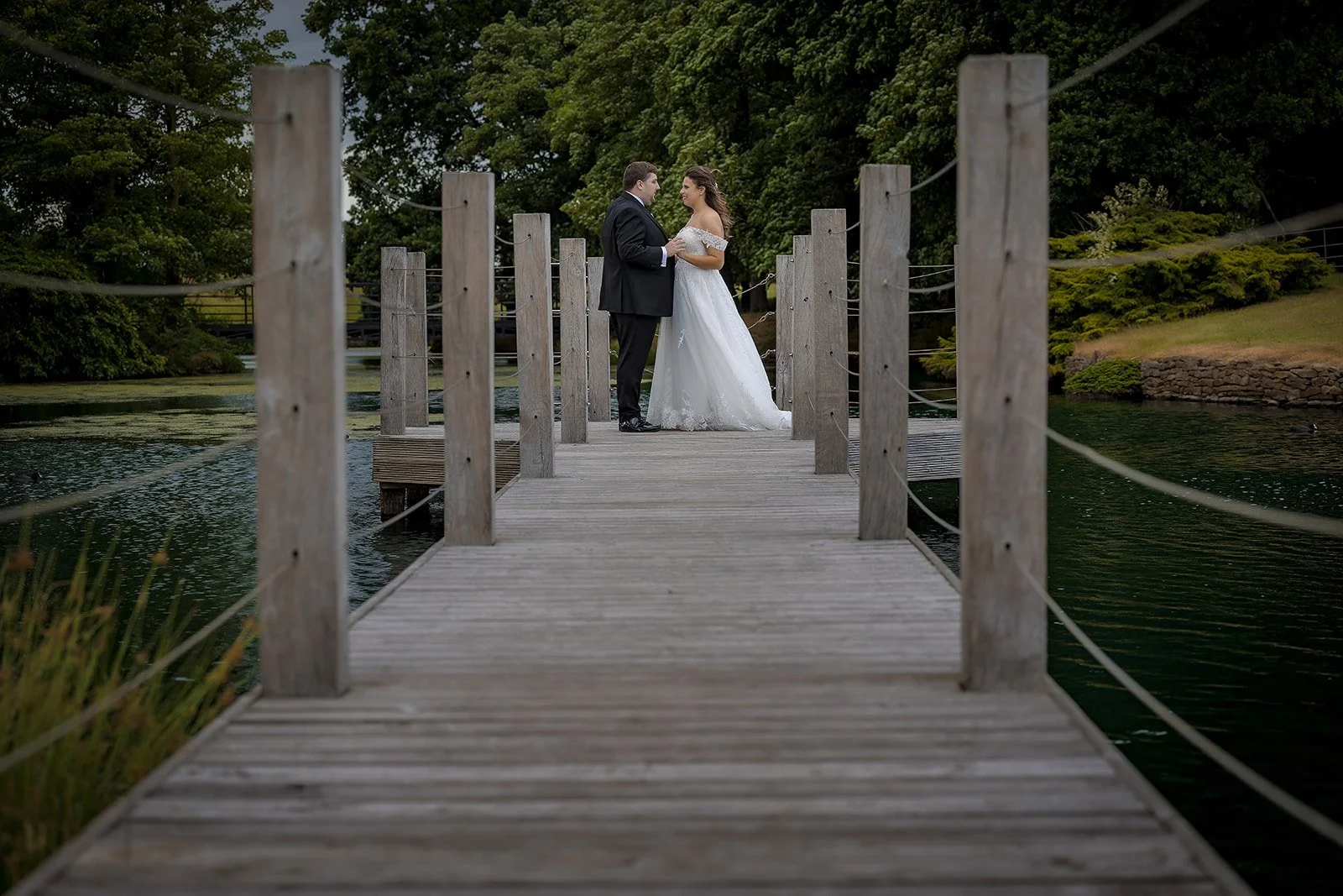 Merrydale Manor wedding couple on lakeside dock holding hands – Manchester wedding photographer