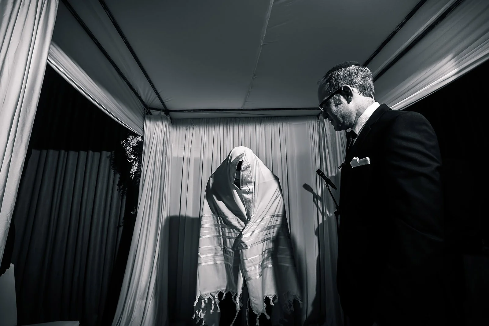 jewish groom covers himself with tallit prayer shawl under the chuppah