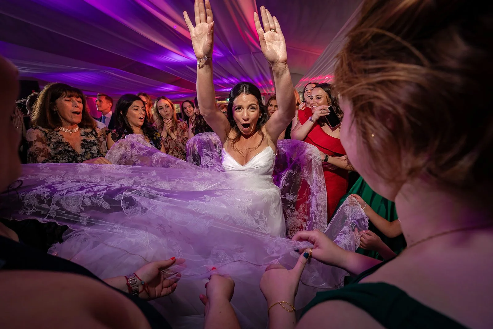 Bride dancing in Nunsmere Hall marquee under purple atmospheric lighting

