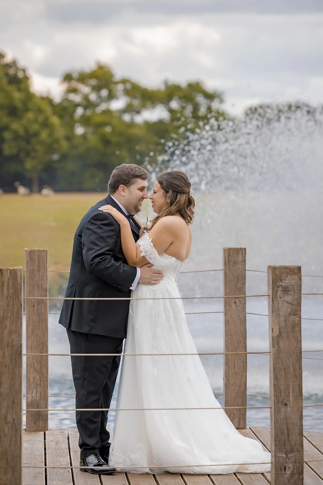 Merrydale Manor wedding couple on dock by fountain in grounds – documentary wedding photography Manchester