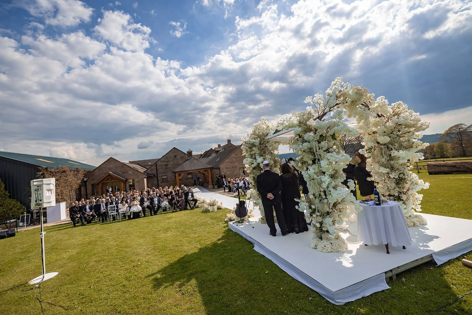 bride and groom exchange vows during outdoor wedding ceremony at heaton house farm in macclesfield