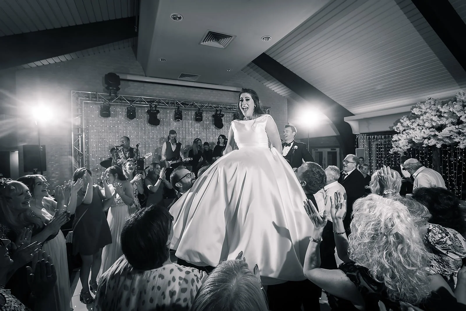 bride lifted on chair on dance floor during reception party at colshaw hall wedding venue