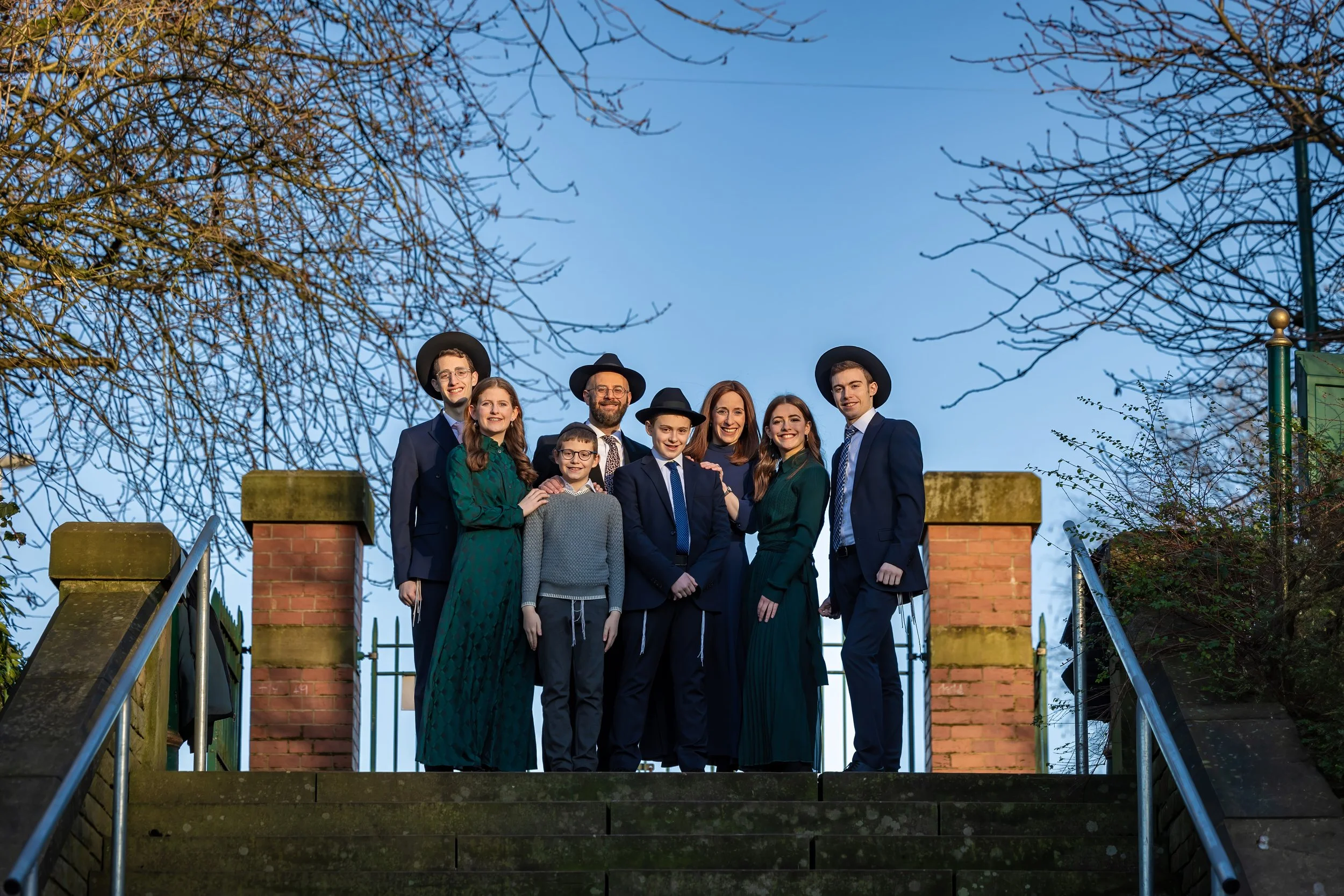 barmitzvah boy and family portrait outdoors with blue sky