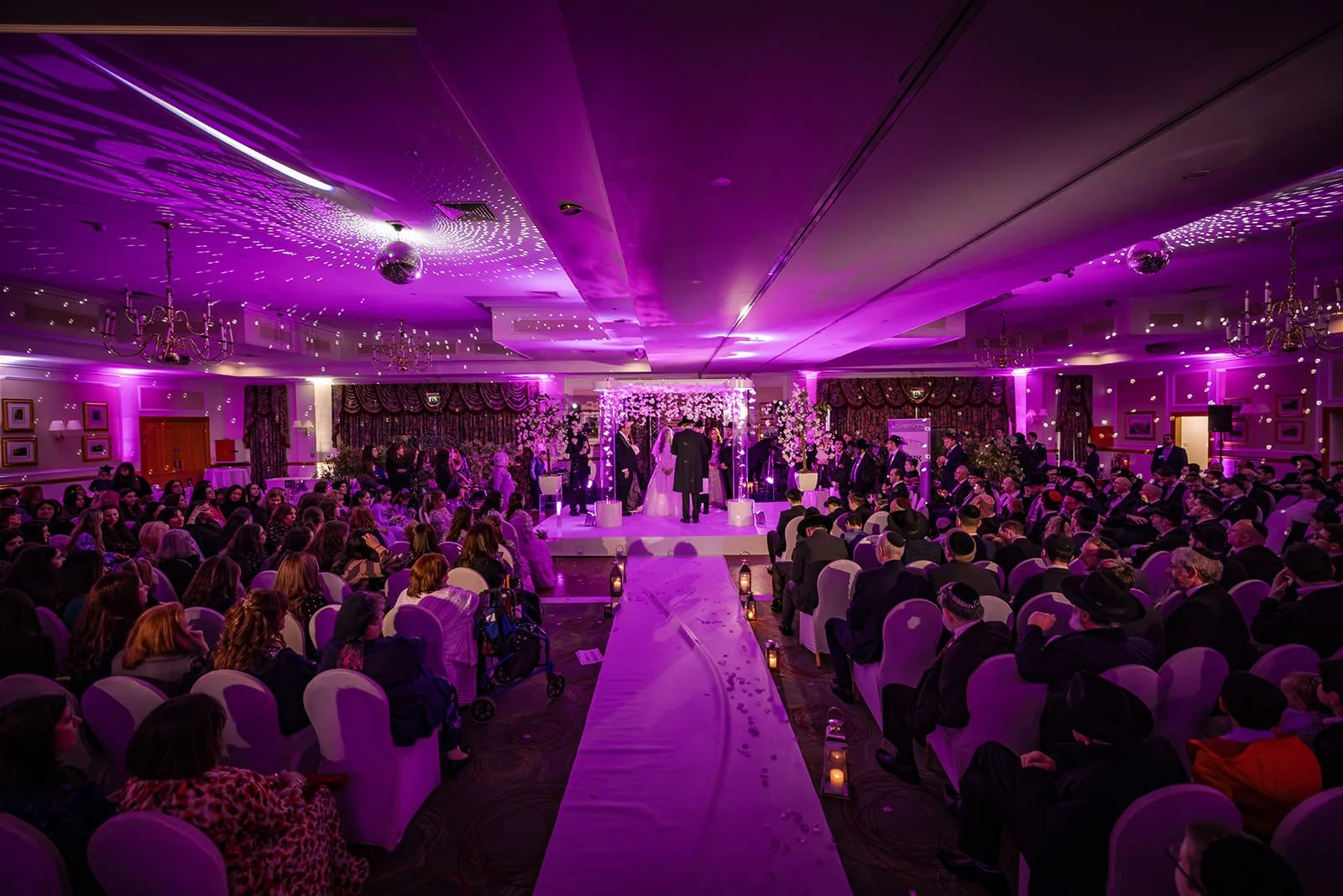 wide angle shot from aisle during indoor wedding ceremony at last drop village in bolton