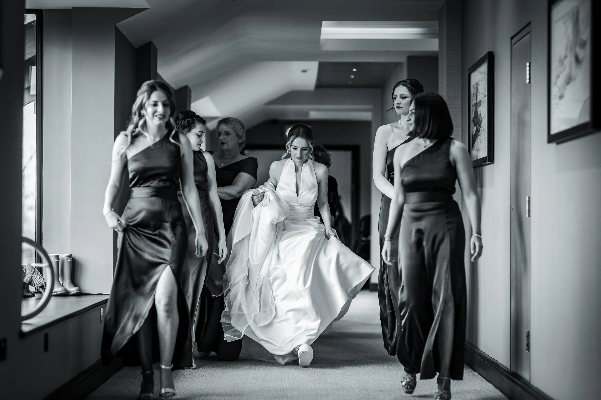 documentary photo of bride and bridesmaids walking in corridor of hotel in Manchester