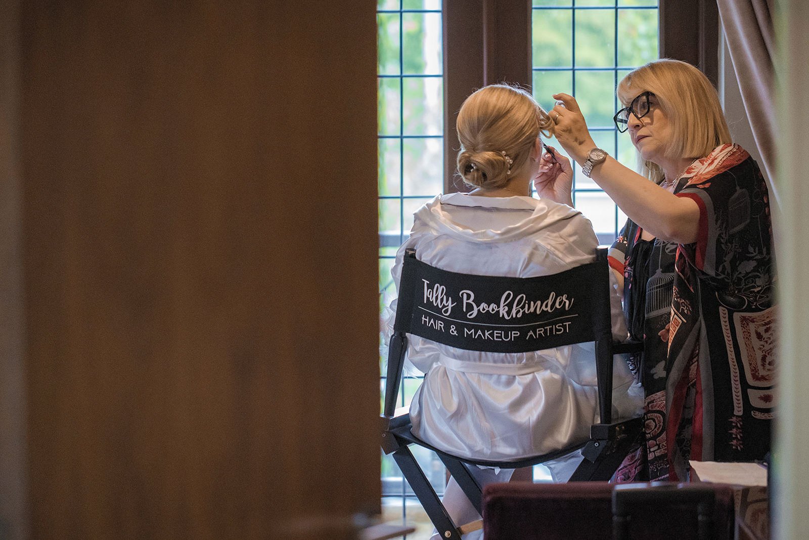 Bride in makeup chair at The Mere, natural light from window
