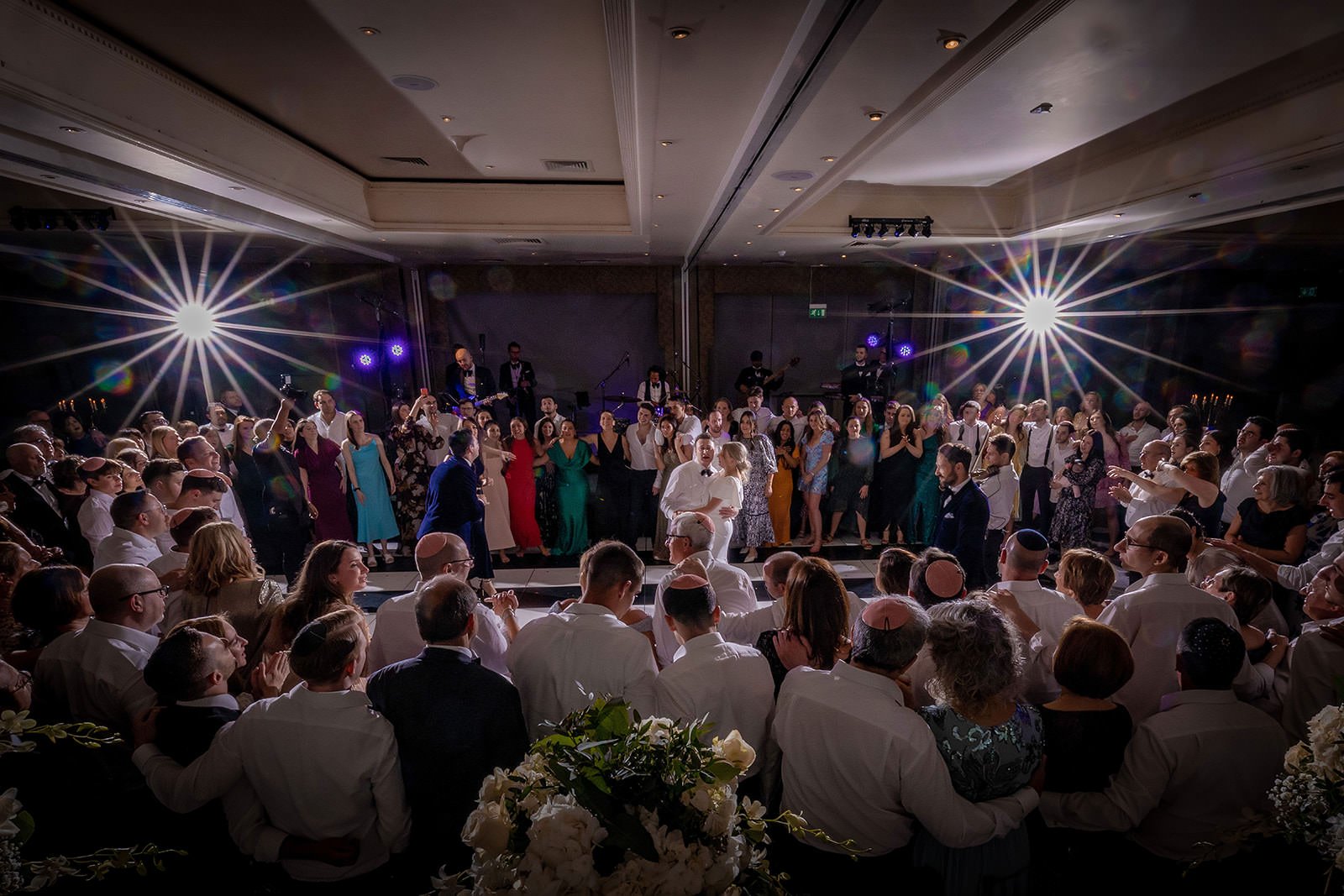 bride and groom surrounded by guests during reception on dance floor at mere golf resort in cheshire