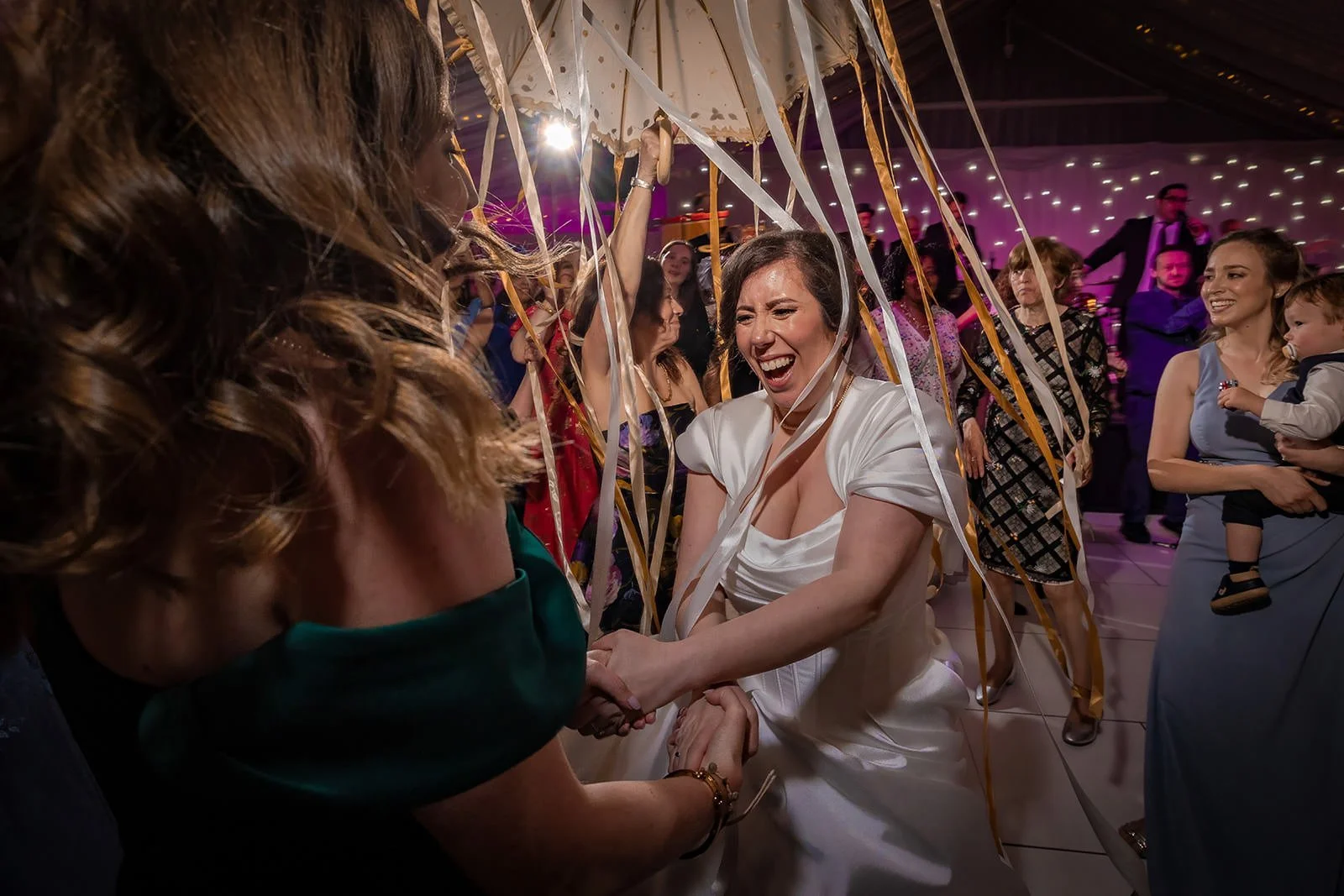 bride dancing with umbrella during wedding reception at heaton house farm