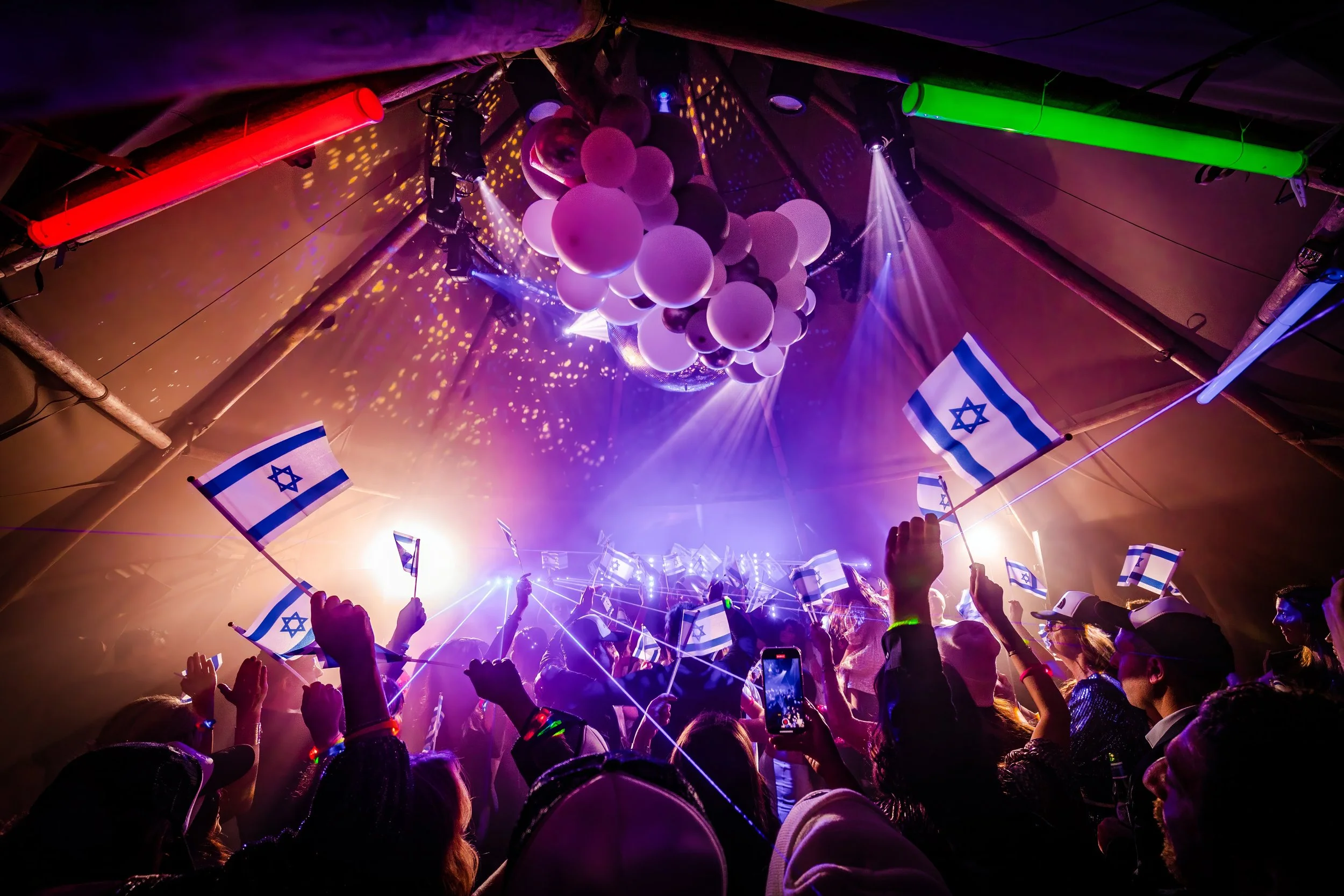 atmospheric crowd shot during barmitzvah dance floor celebrations in Manchester with flags