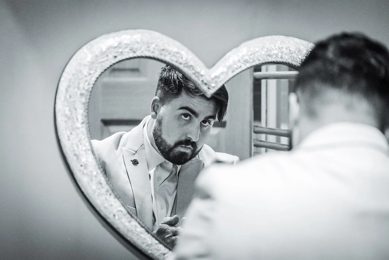 Merrydale Manor wedding groom looking in heart-shaped mirror detail – fine art wedding photographer North West