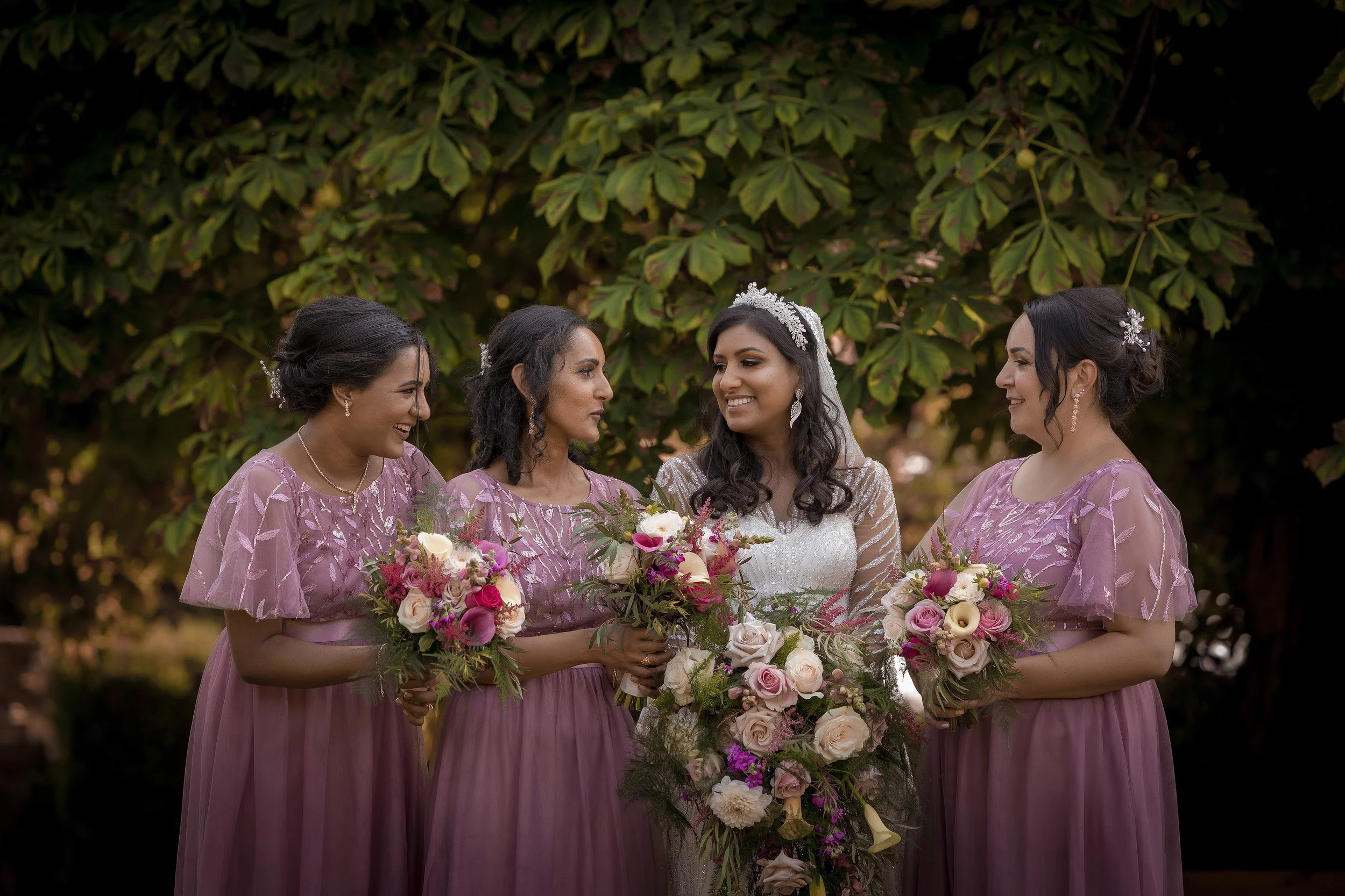 Bride and bridesmaids portrait with bouquets and smiling