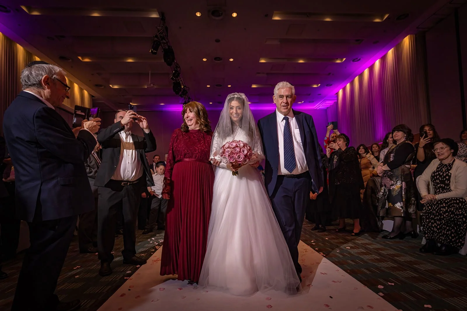 bride and parents walk down aisle during wedding ceremony at manchester deansgate hotel