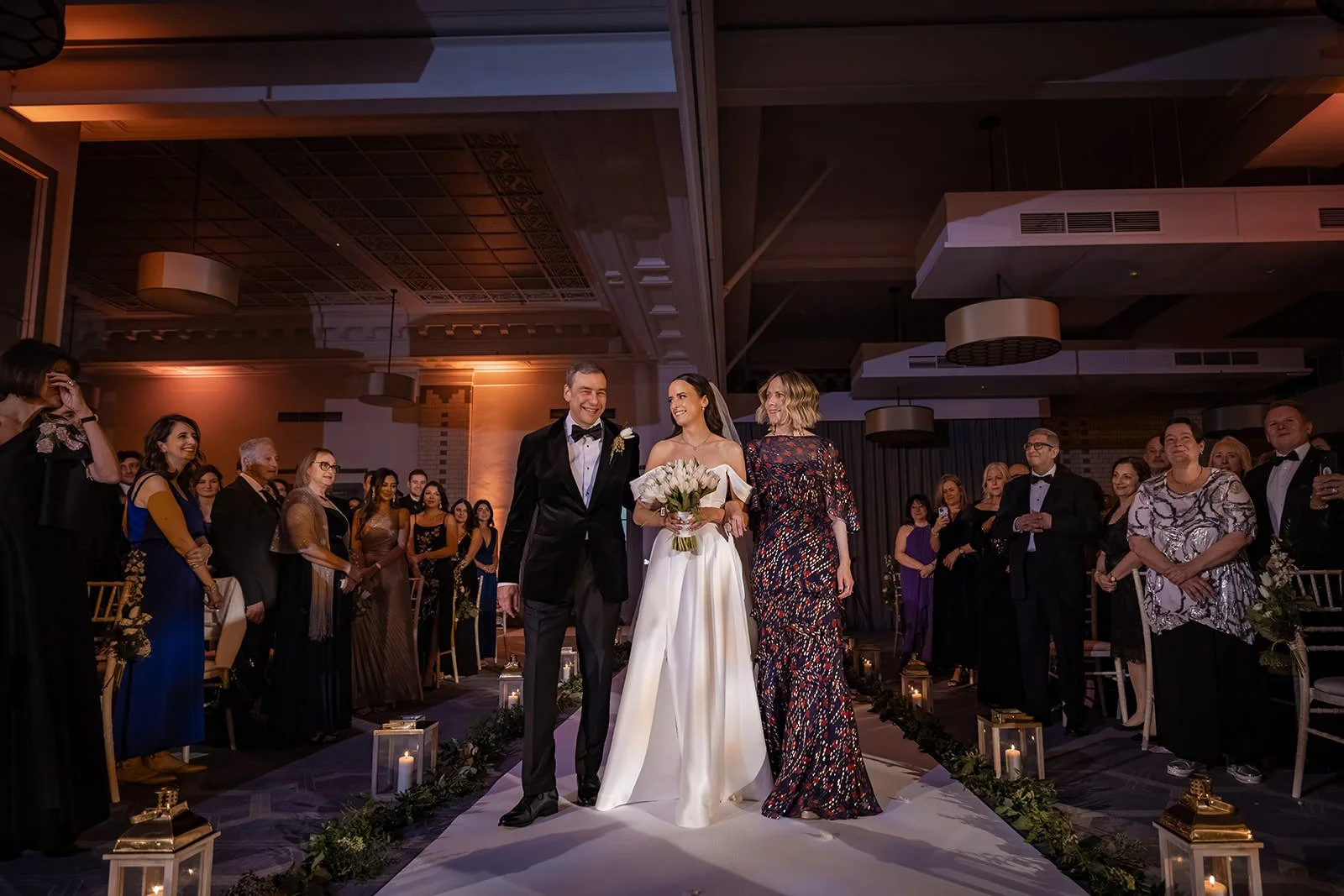 bride and parents walk down aisle at start of wedding ceremony in ballroom at kimpton clocktower manchester