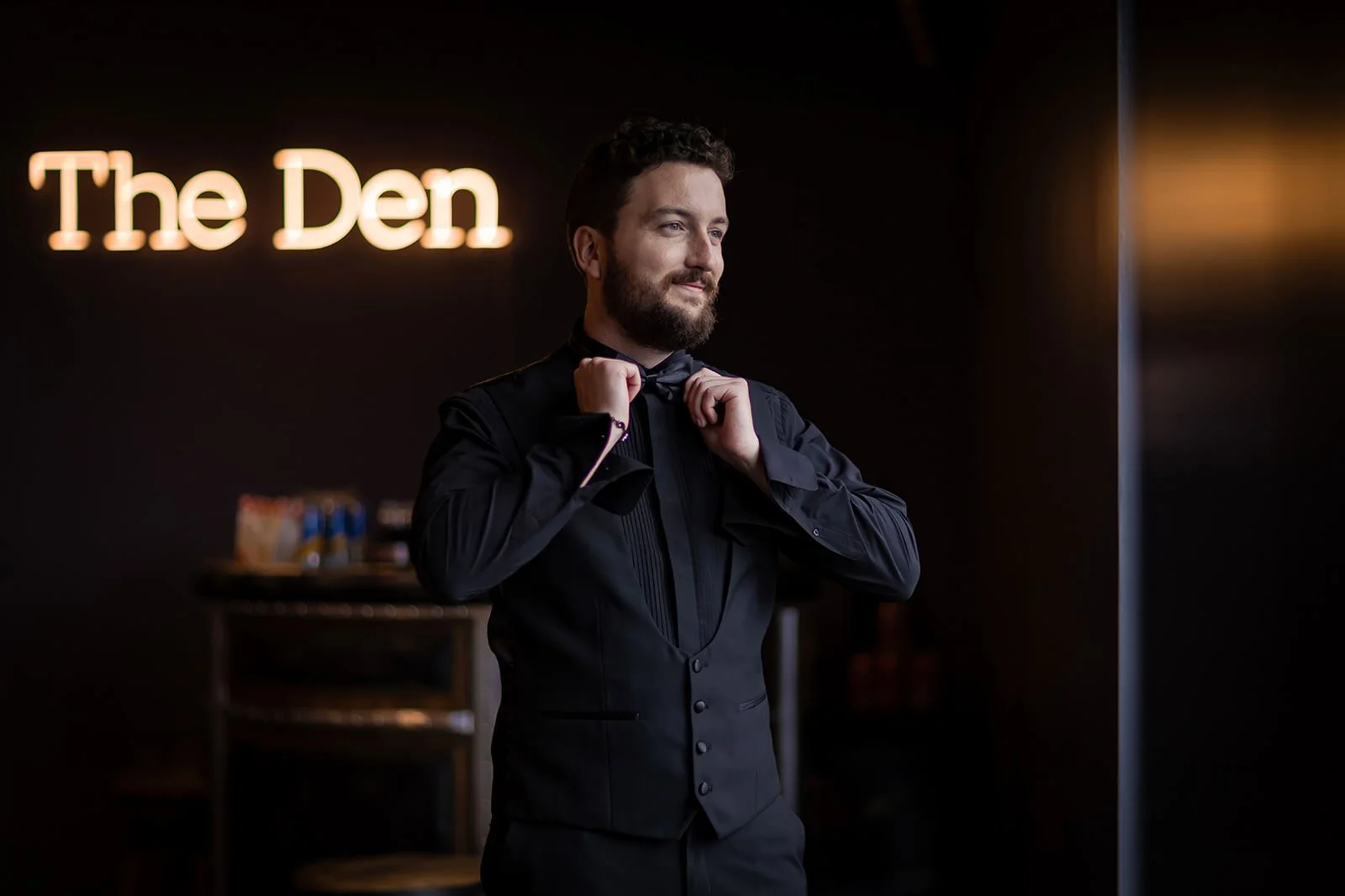 groom getting ready during prep with natural light in the den at colshaw hall