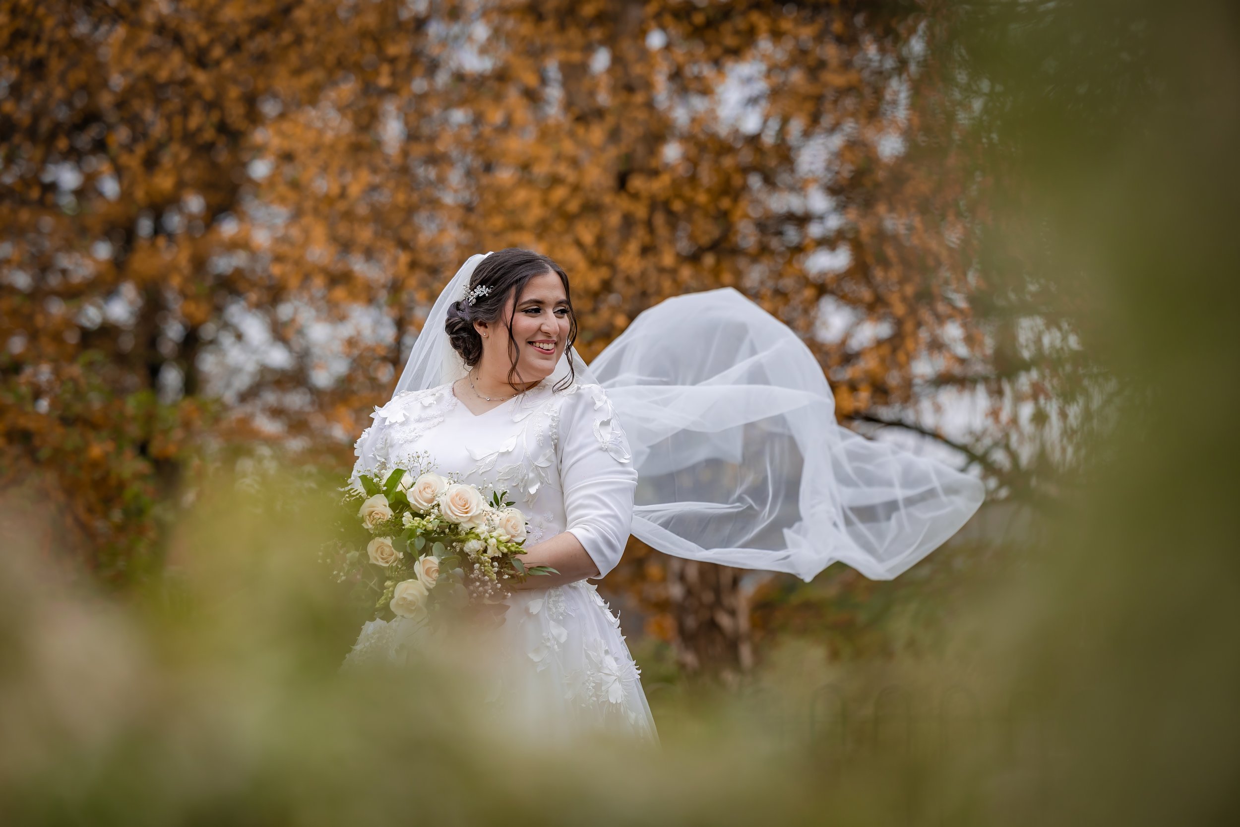 portrait of kallah bride with flowing veil in park