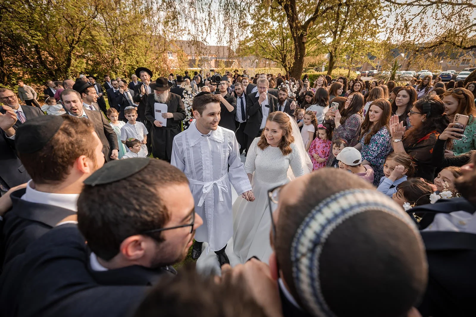 bride and groom leave outdoor wedding ceremony at last drop village in bolton