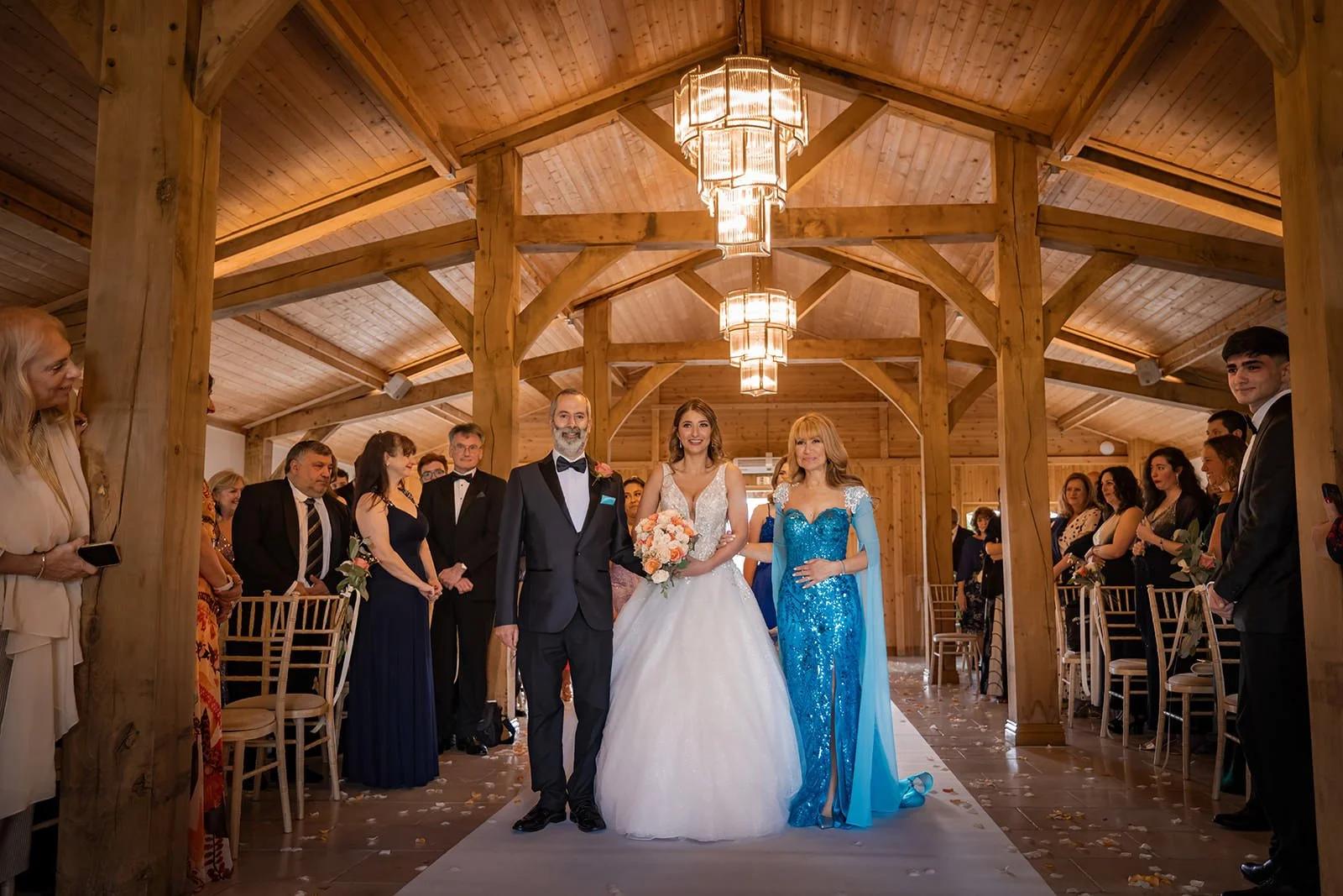 bride walks down aisle with parents during ceremony at colshaw hall in cheshire