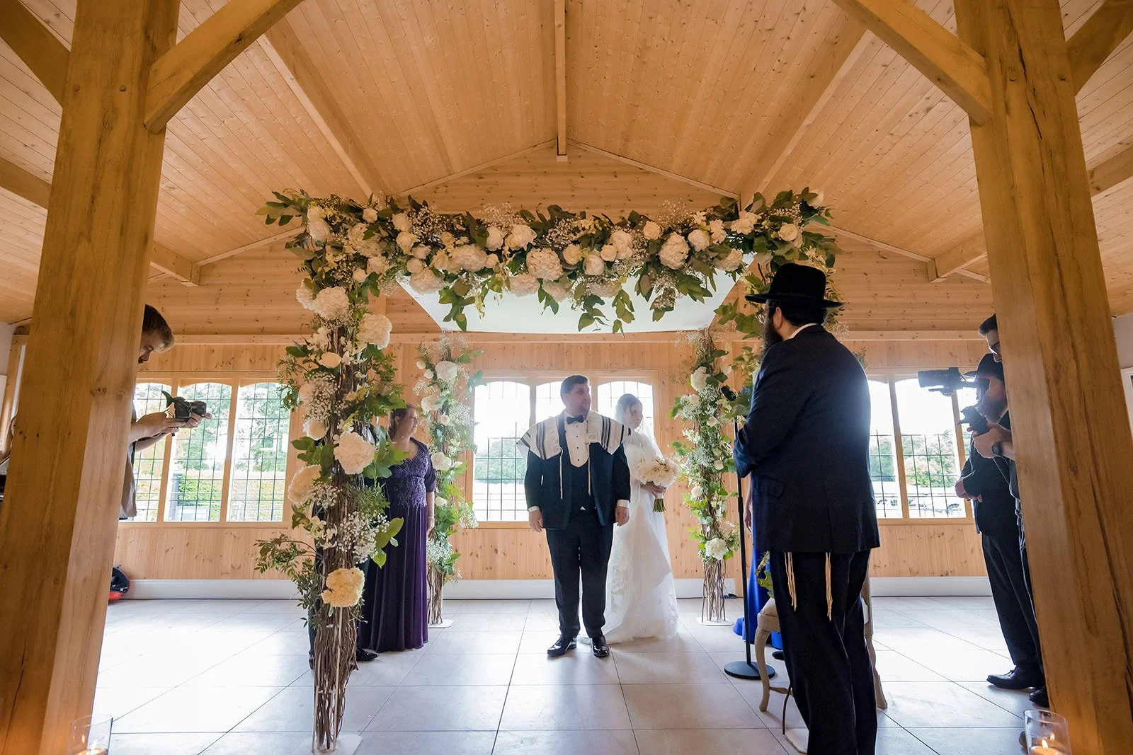 Merrydale Manor wedding ceremony couple under white floral arch – documentary wedding photography Manchester