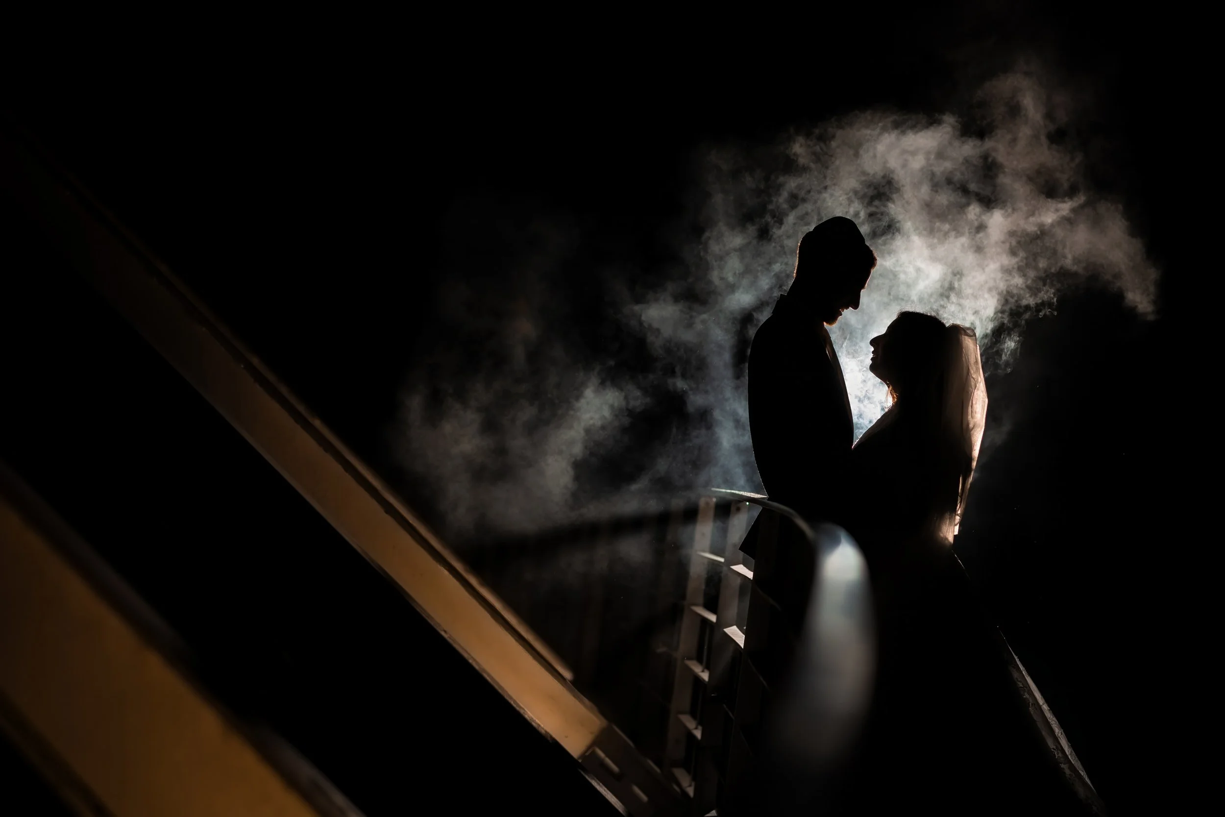 atmospheric silhouette of kallah bride and chosson groom portrait on bridge with smoke
